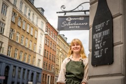 Kvindelig tjener foran restaurant