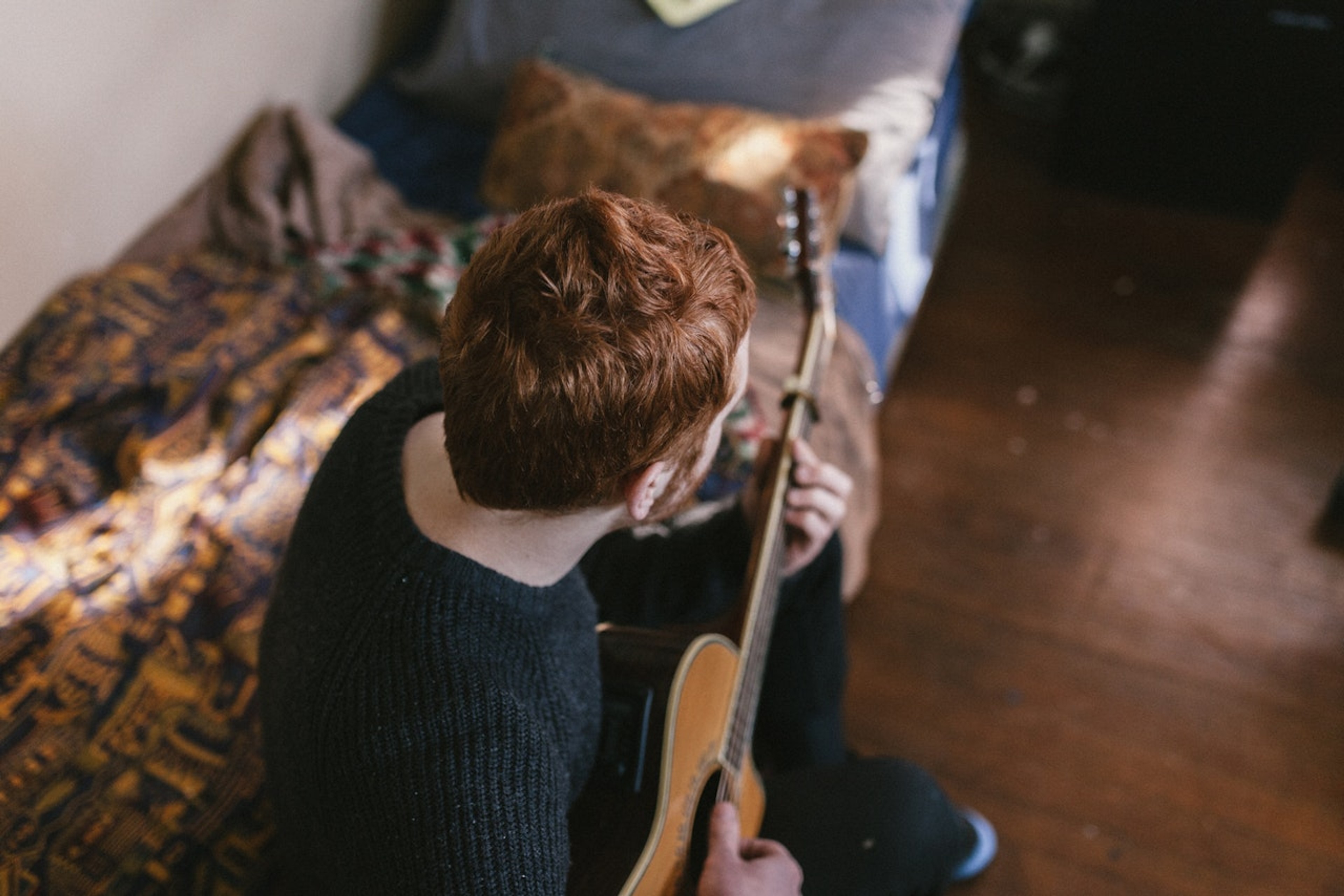 Guitarist sidder på seng