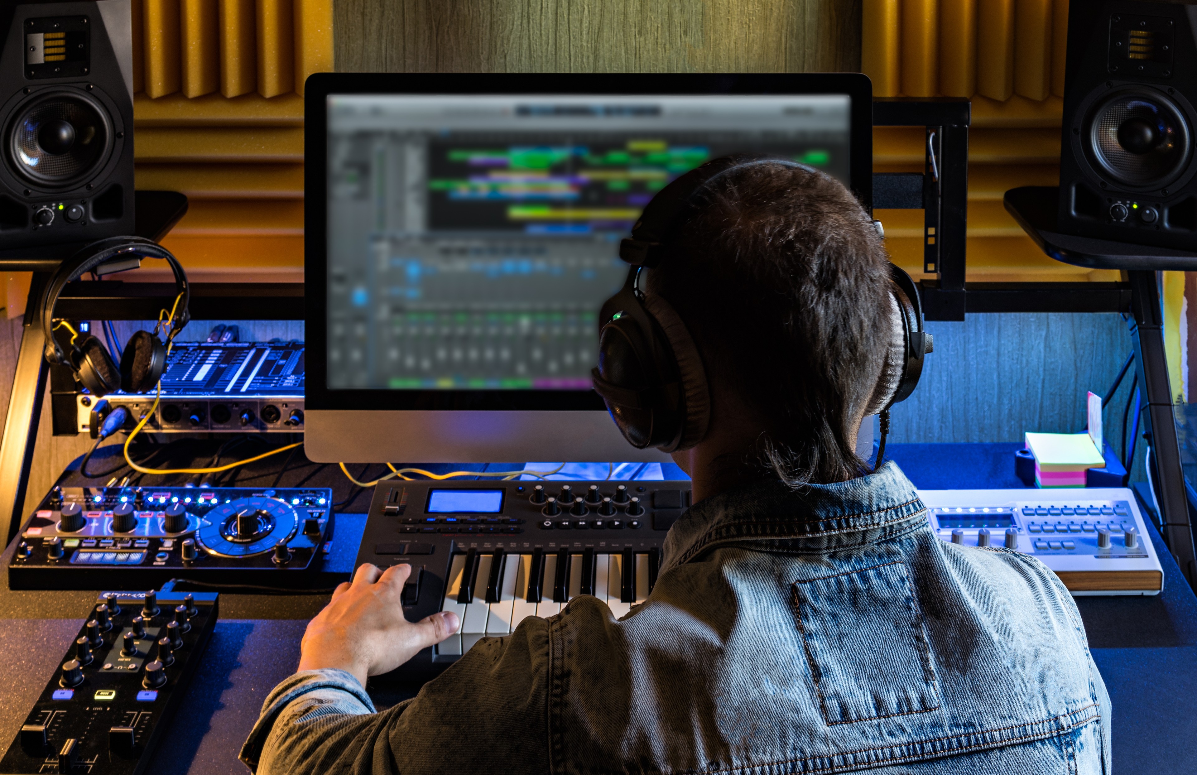 Person foran computer og keyboard indspiller musik