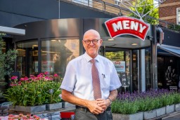 Købmand står foran blomsterne ved Meny