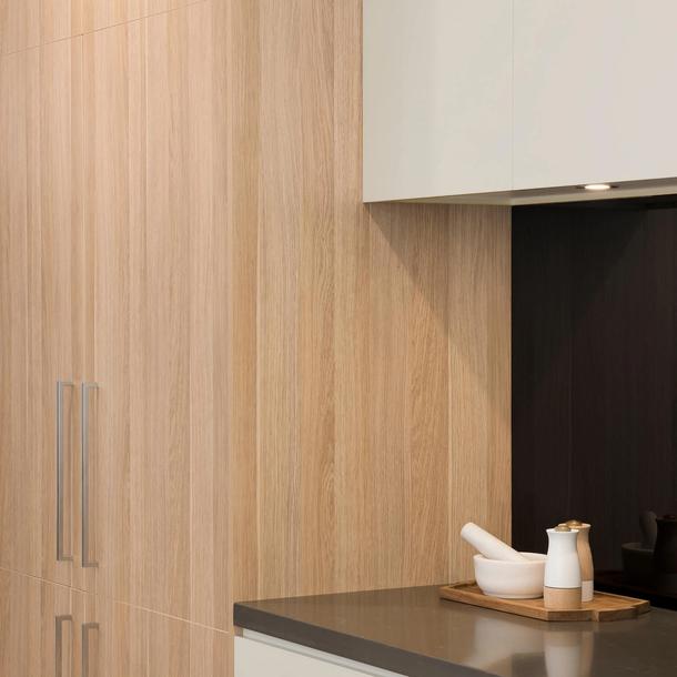 Closeup image of a Colourpyne kitchen showing a pantry doors in a light oak and white cabinetry