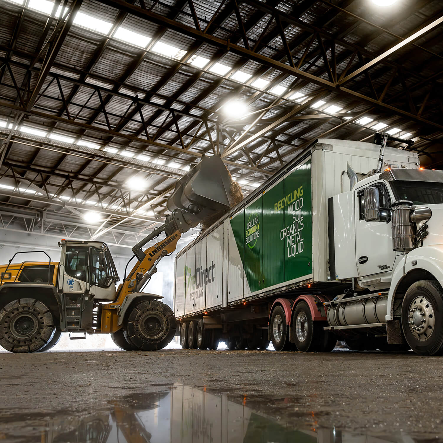 A digger lifting recycled timbers into a redirect recycling truck.