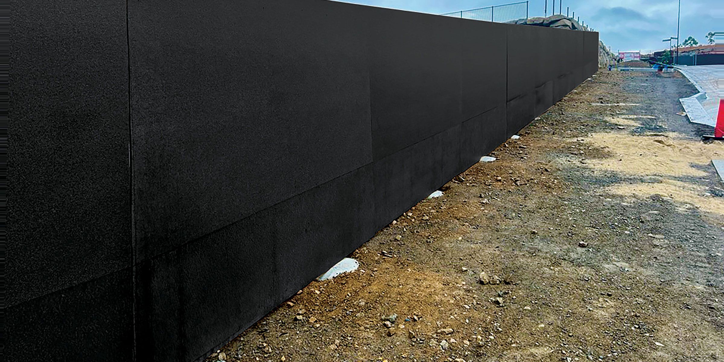 A closeup of STRUCTApanel® Black installed as hoarding about a new Impact Designer Homes site