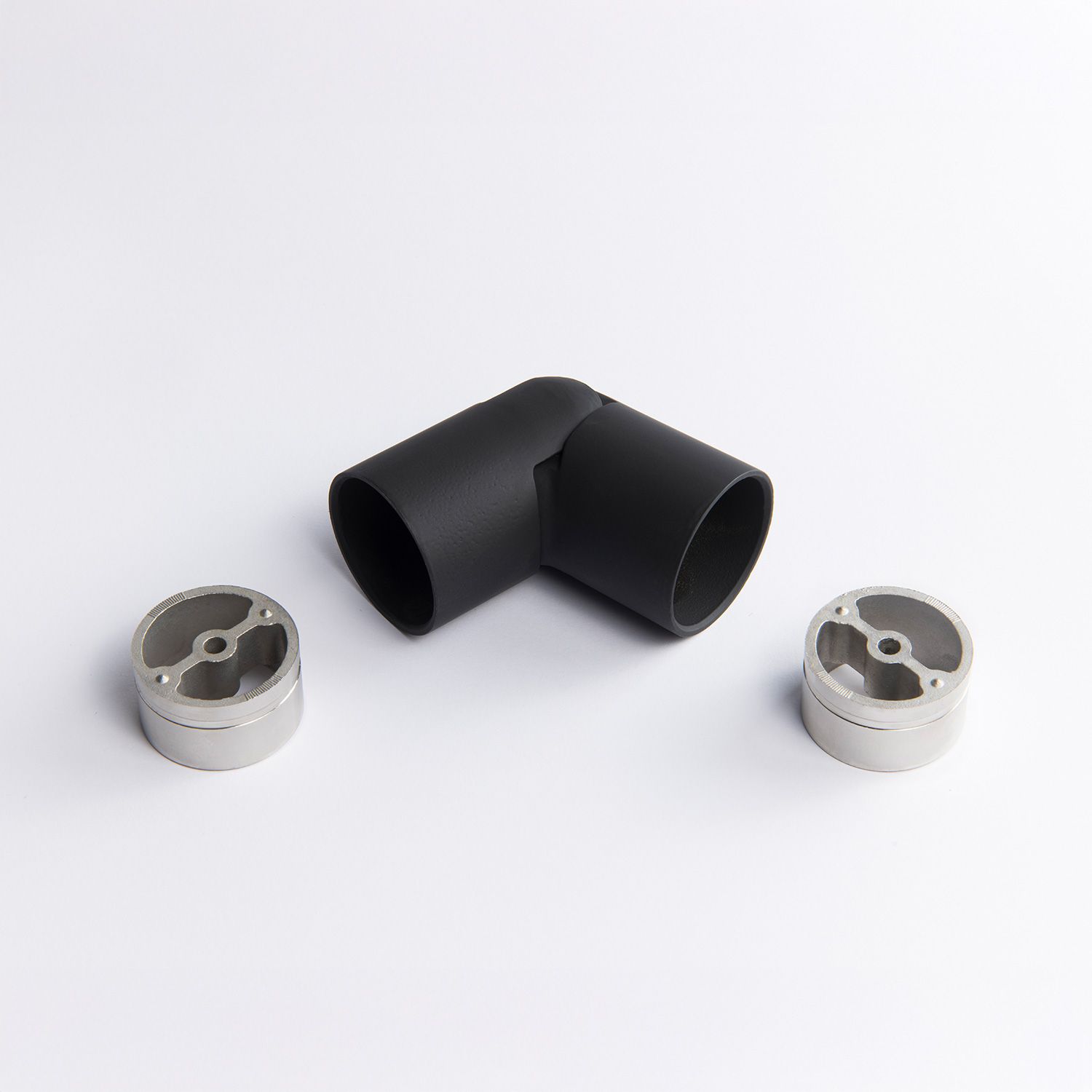 A flexible black metal tube connector positioned between two silver circular mounting inserts  43mm