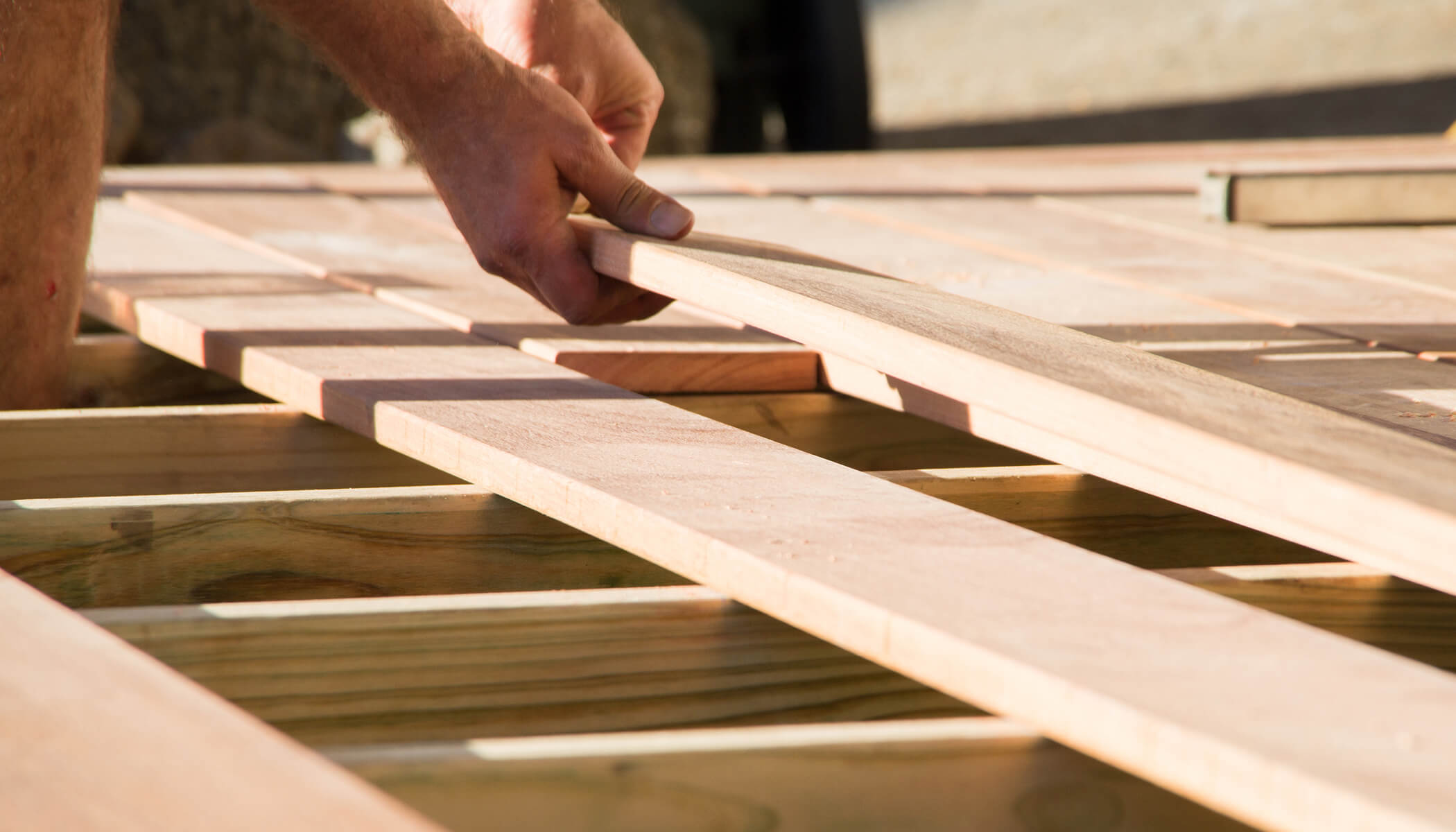 A person building a deck with their hands