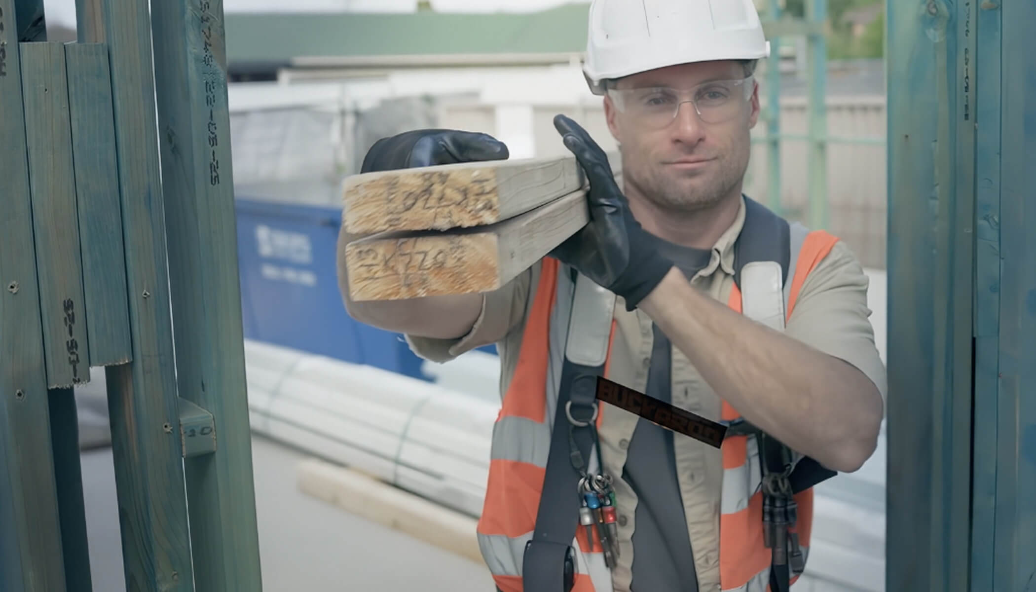 A construction worker carrying a STRUCTAframe™ on a construction site.