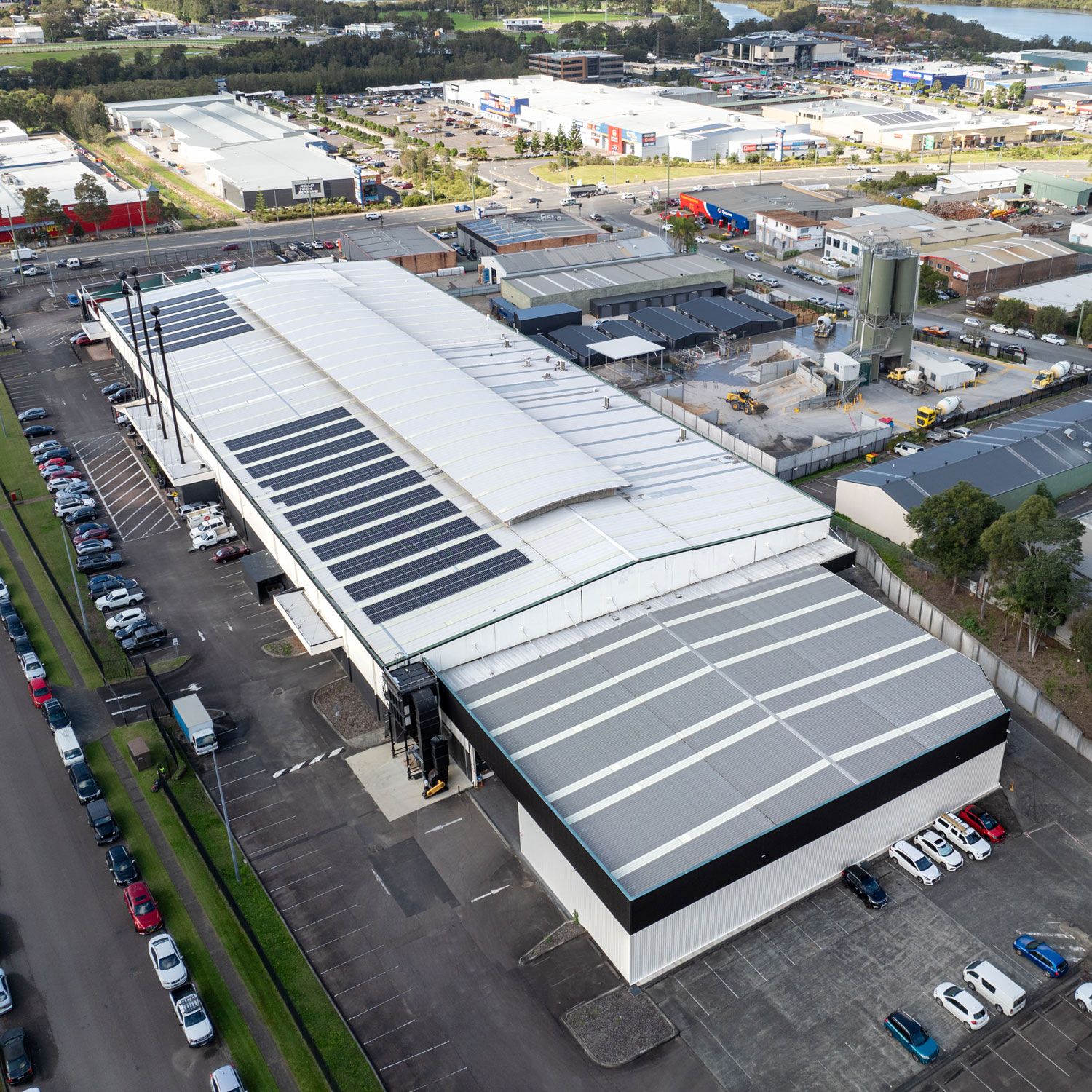 An aerial overview of a factory with solar panels on the roof