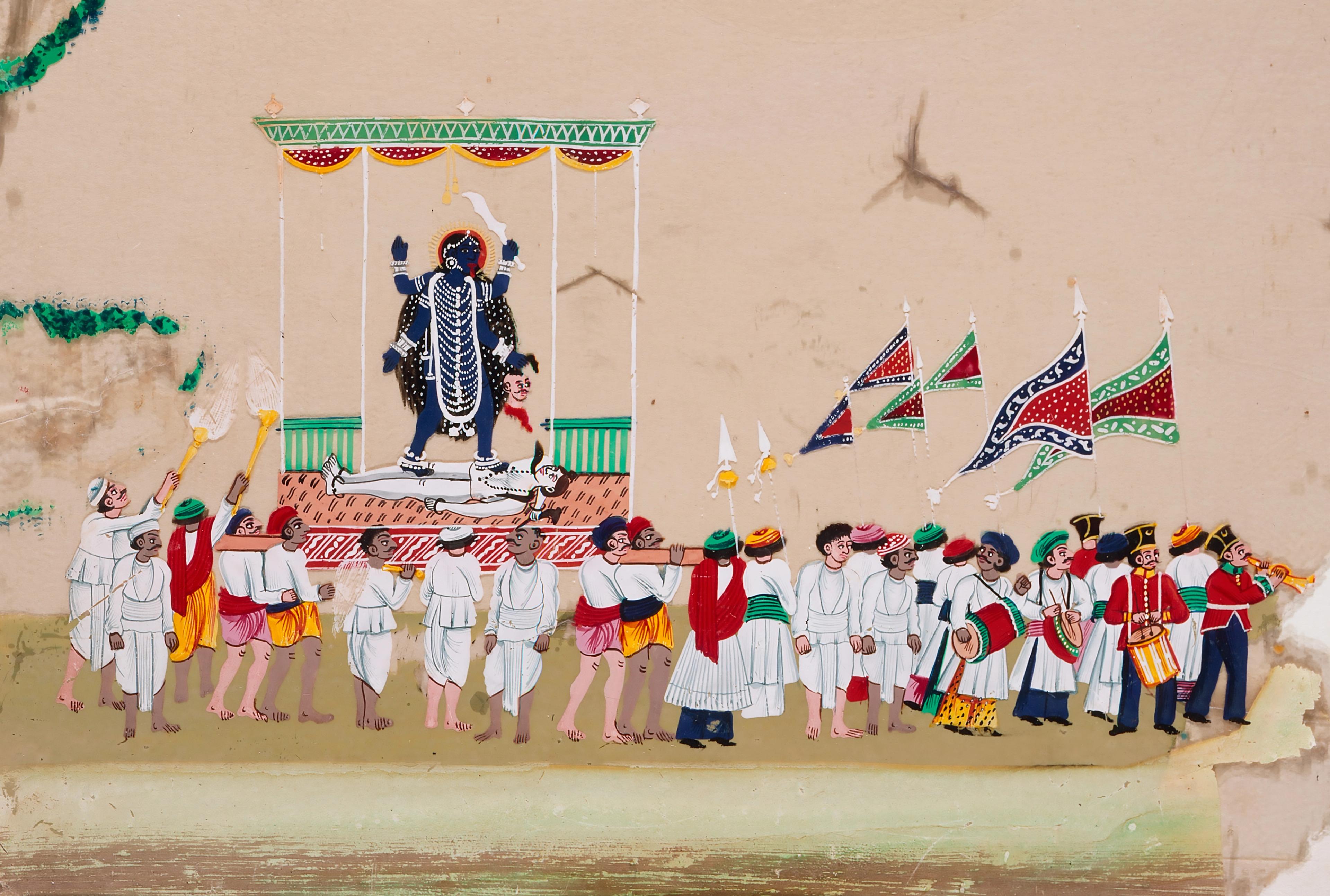 A parade of people. The leaders carry flags, and in the rear, several hold Kali in her signature pose.