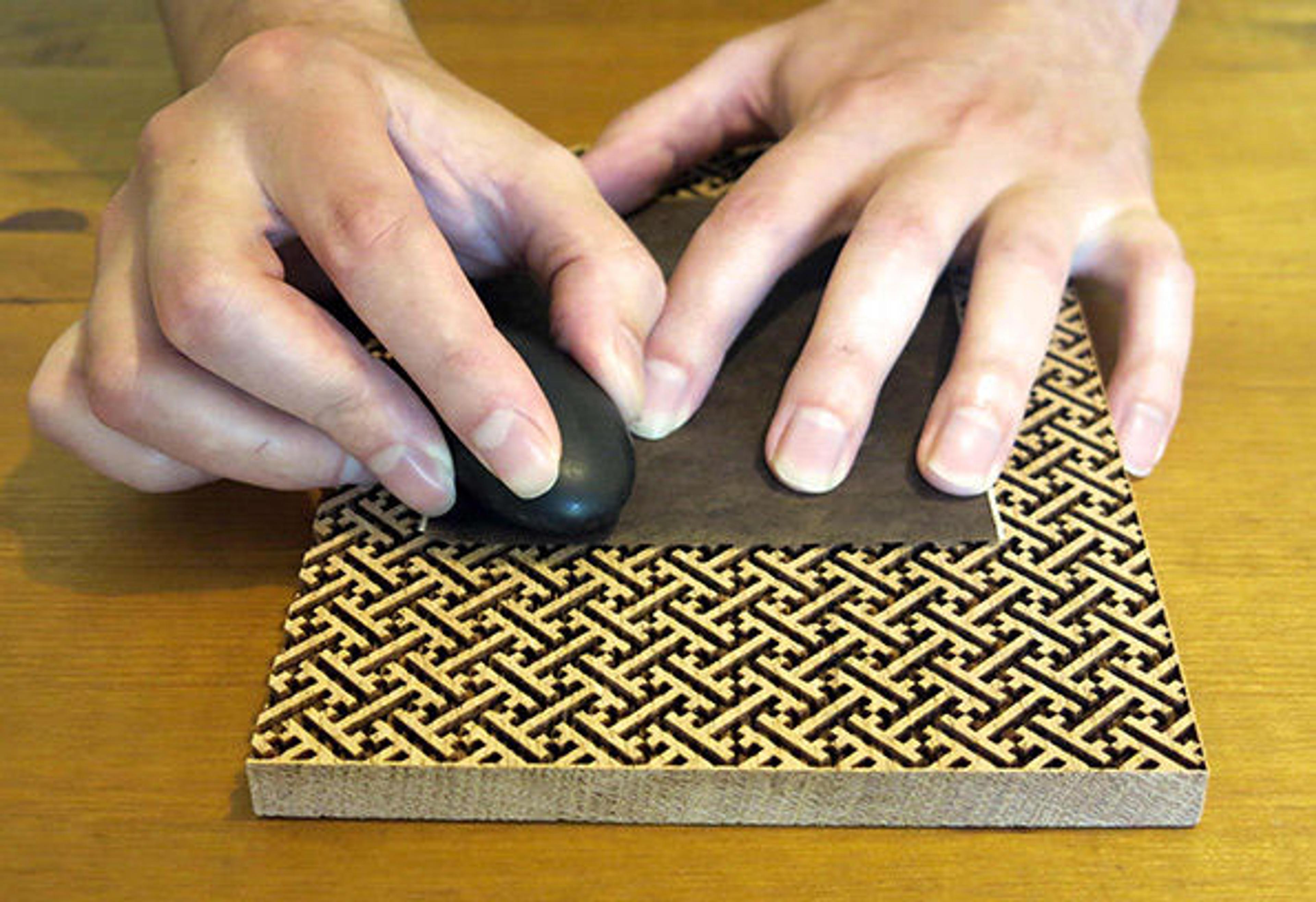Kazuko Hioki’s slide showing how a stone was used to create decorative burnished papers by rubbing over a textured wood block