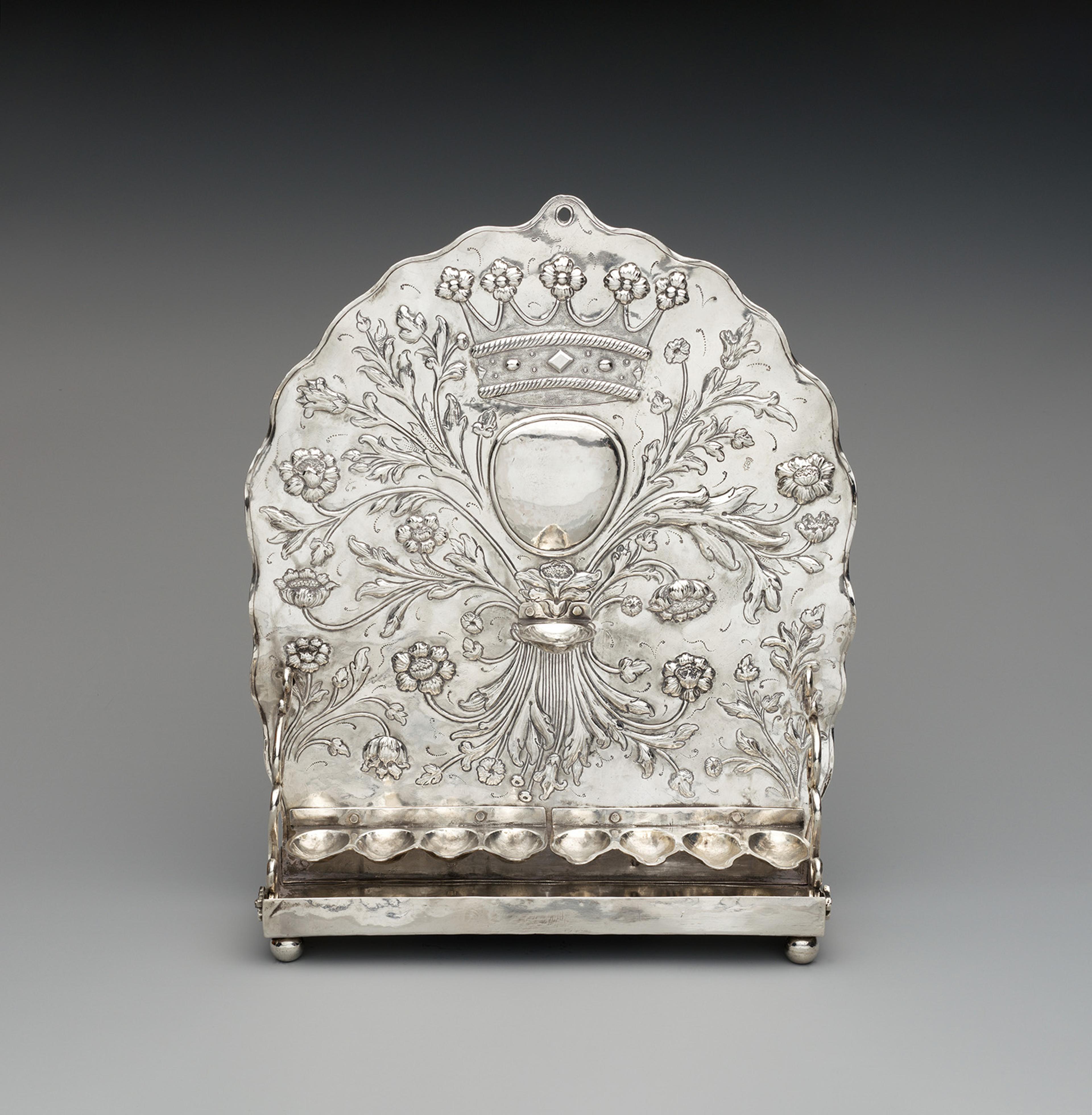 Ornate silver candle snuffer tray with intricate floral engravings and a crown emblem