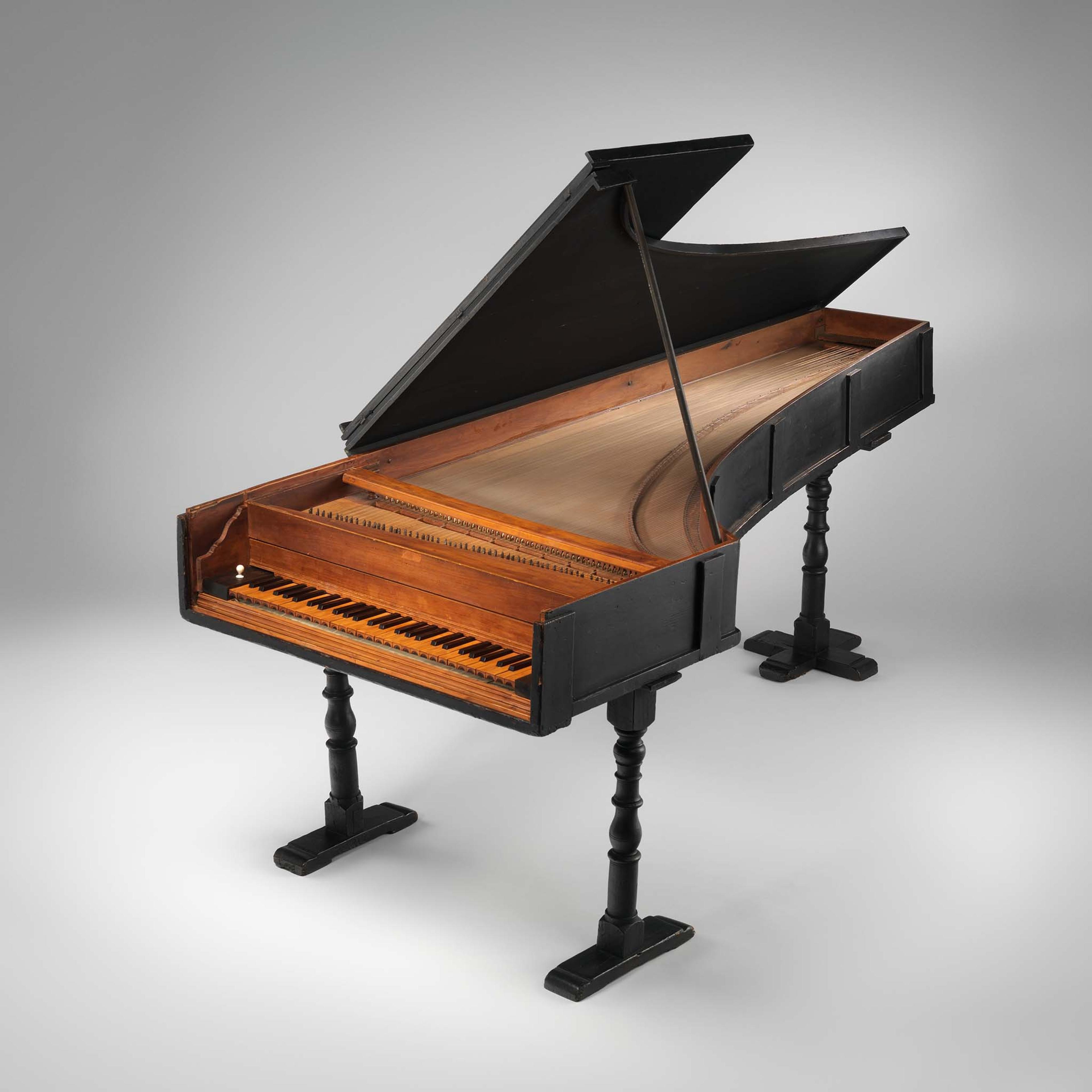 Cristofori's eighteenth-century grand piano, designed with rich, reddish wood against a gray background.