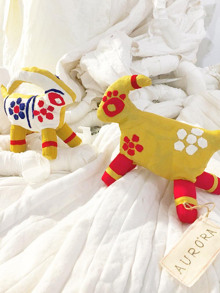 Small white and yellow goats made from clothing scraps