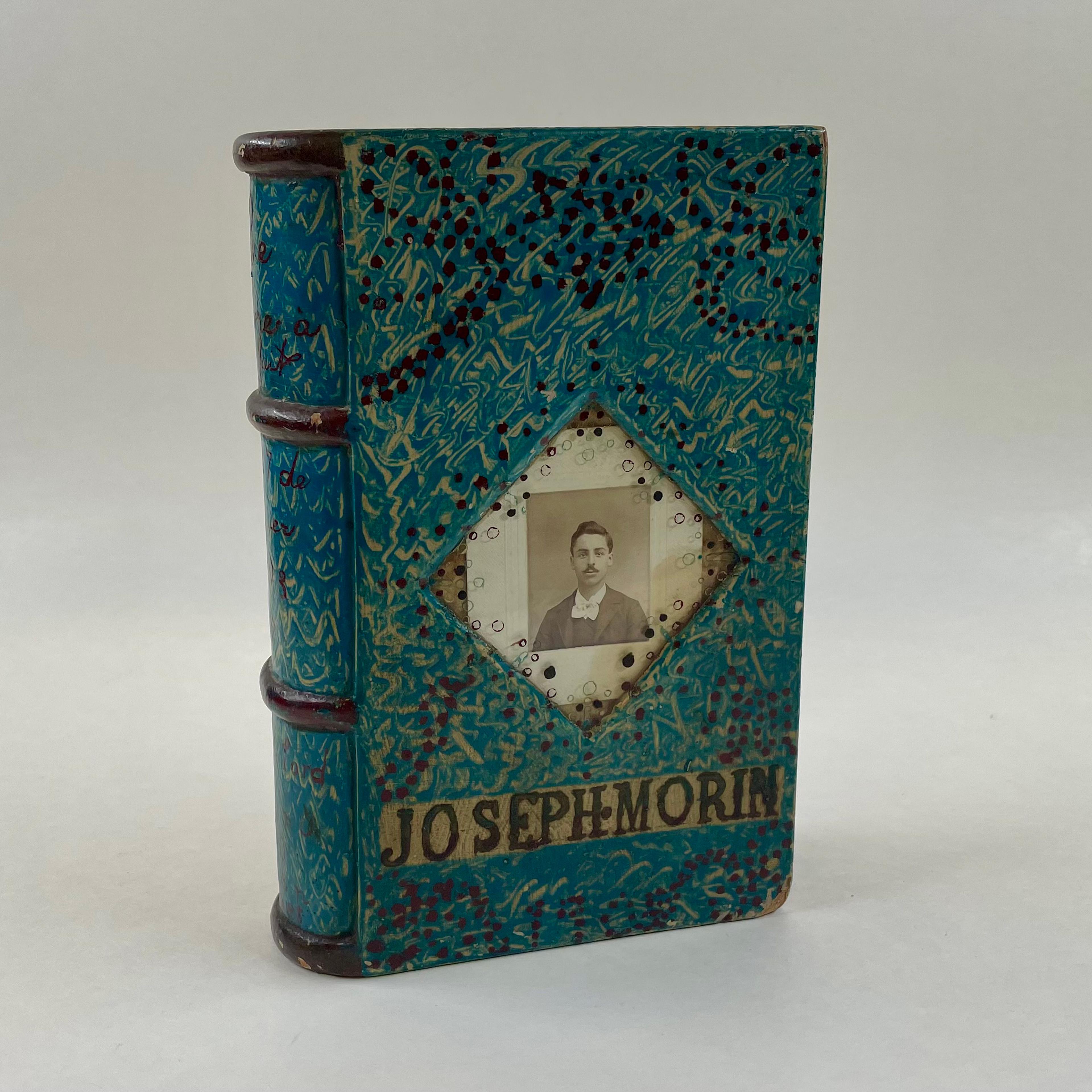 Cover of a box in book form that includes a black and white portrait of a man