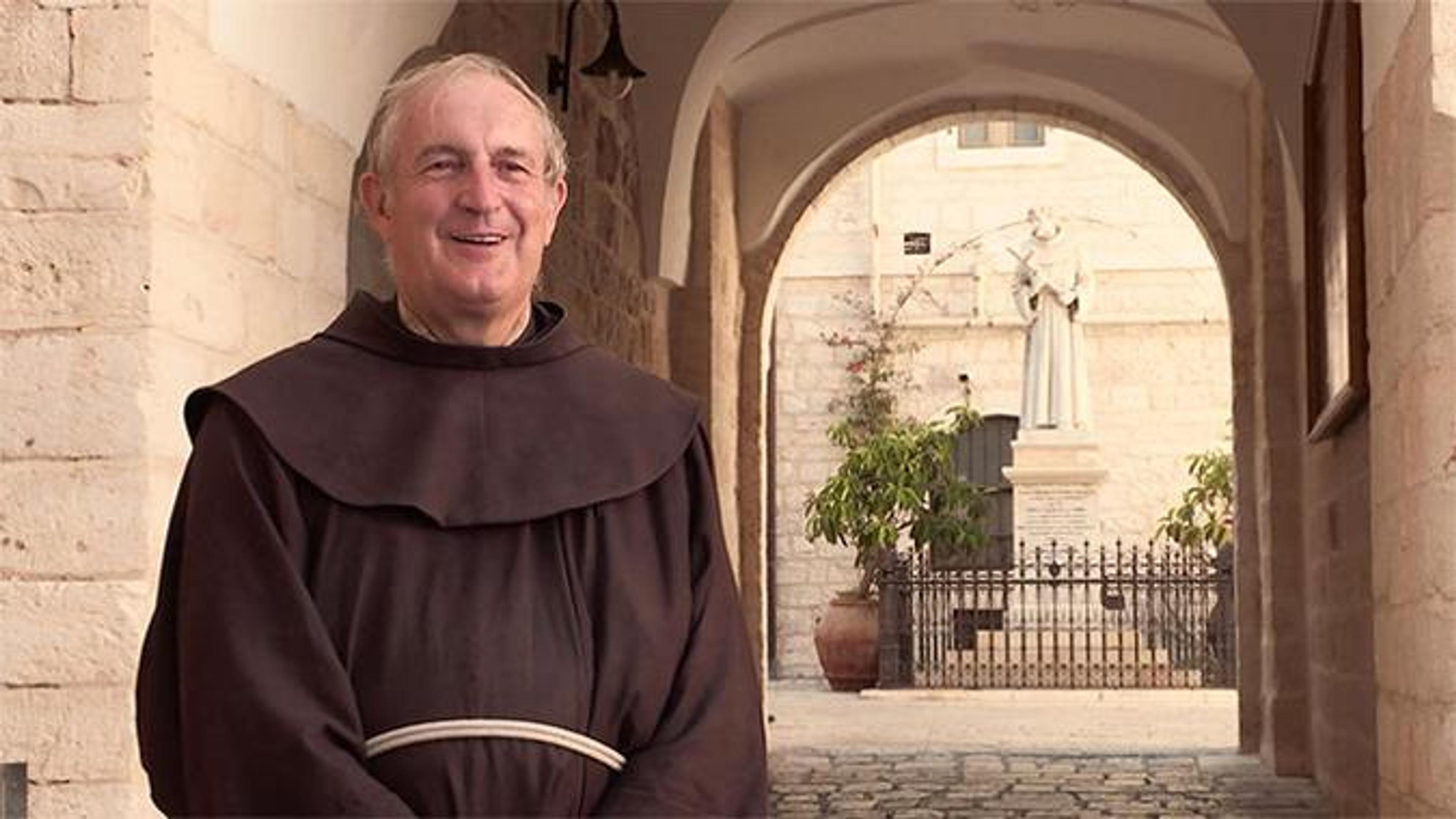 A friar standing in front of an arch