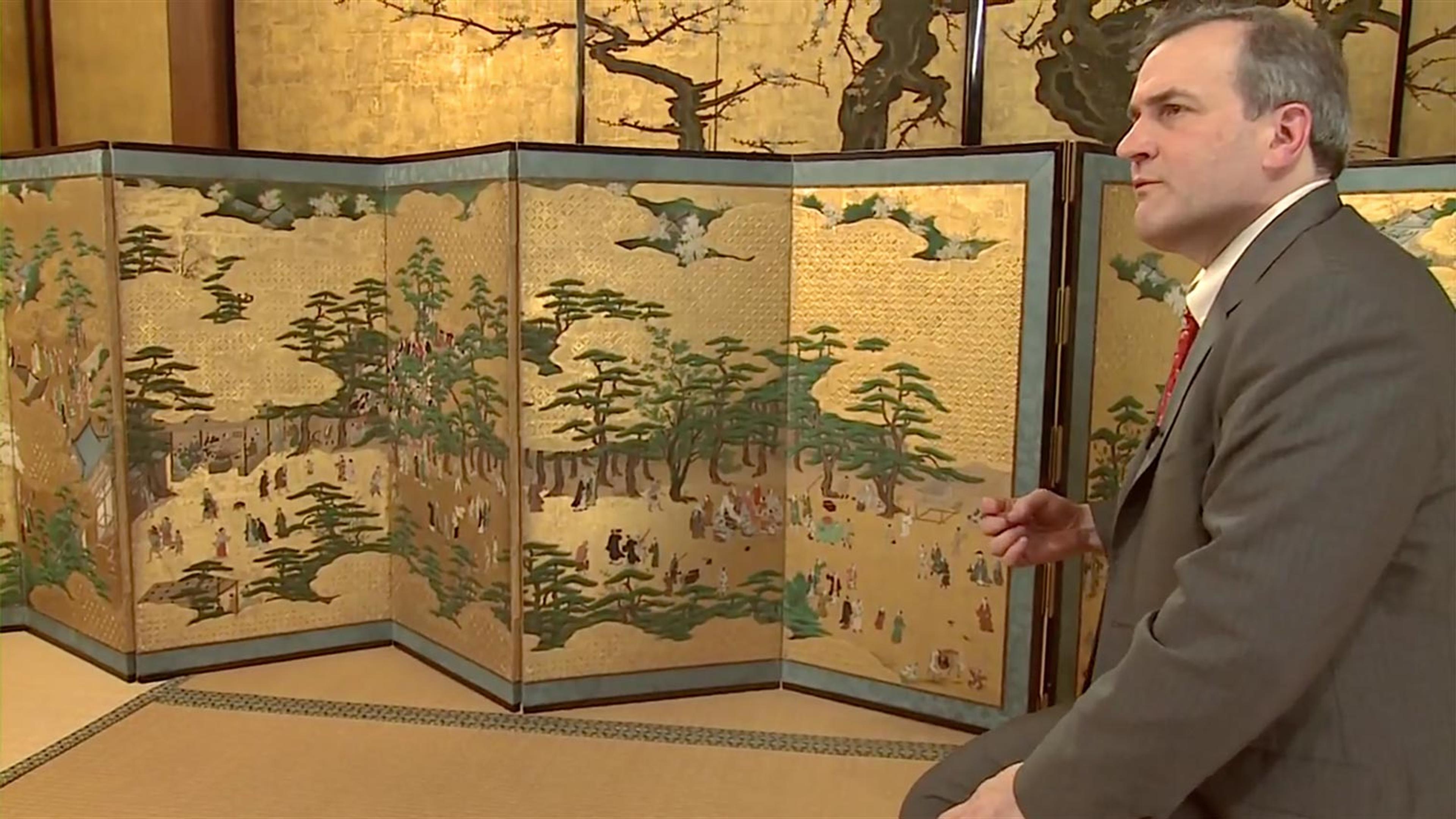 An ornate painted screen depicting scenes of daily life in Kyoto