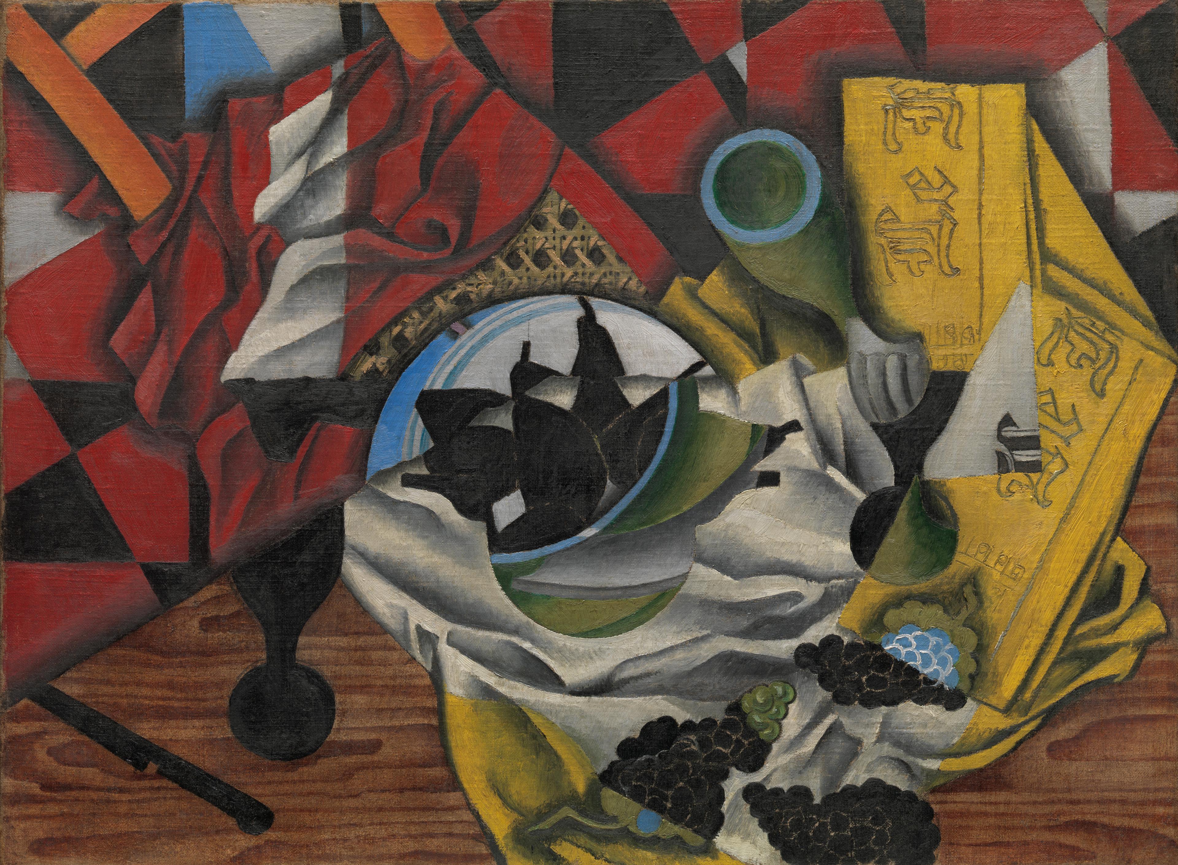 Red and yellow oil painting of a table hastily left with pears, grapes, a knife and crumpled napkin on it called "Pears and Grapes on a Table" by Juan Gris.
