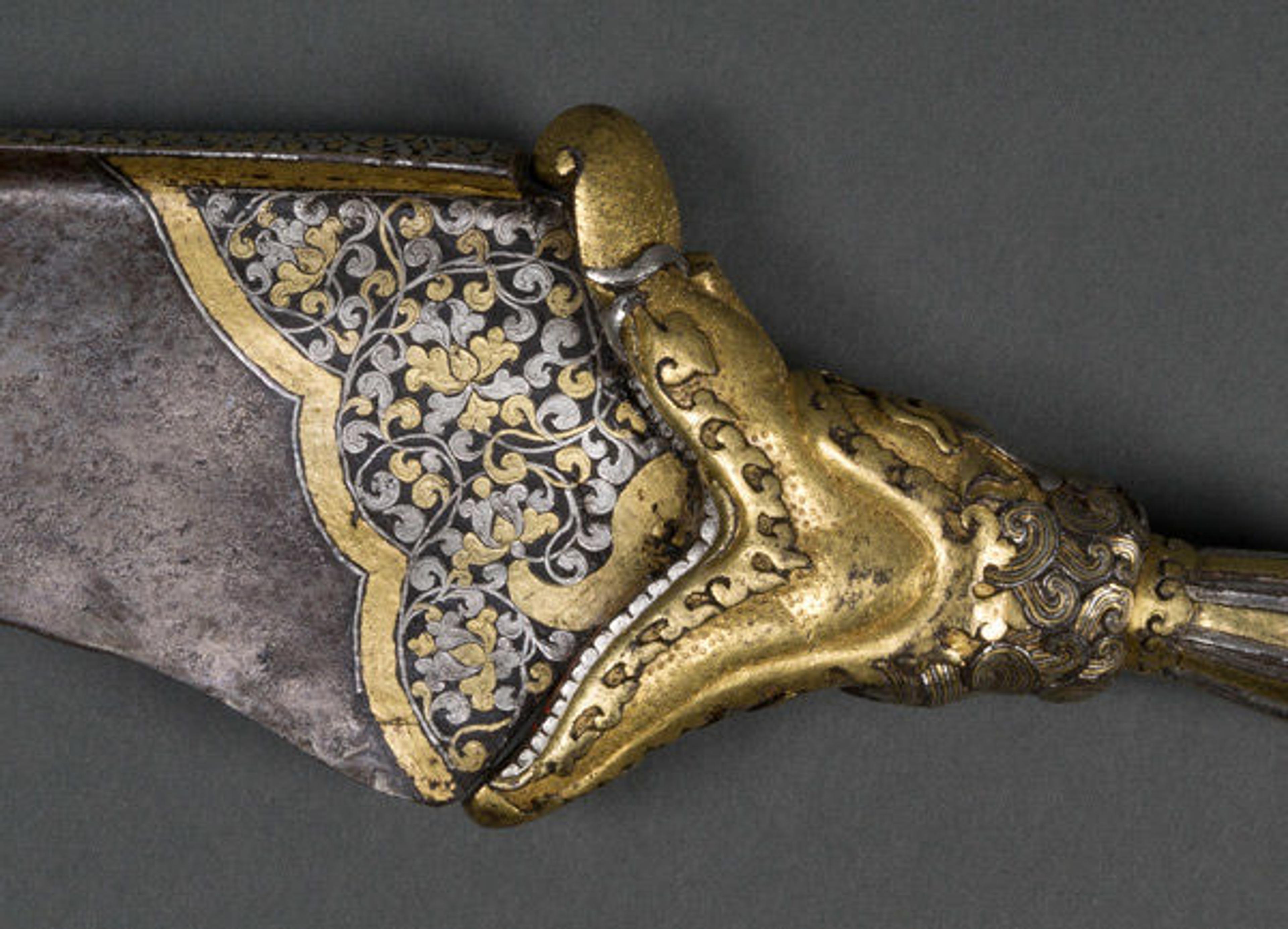 Detail of open-mouthed makara-head hilt leading into foliage on the knife's blade