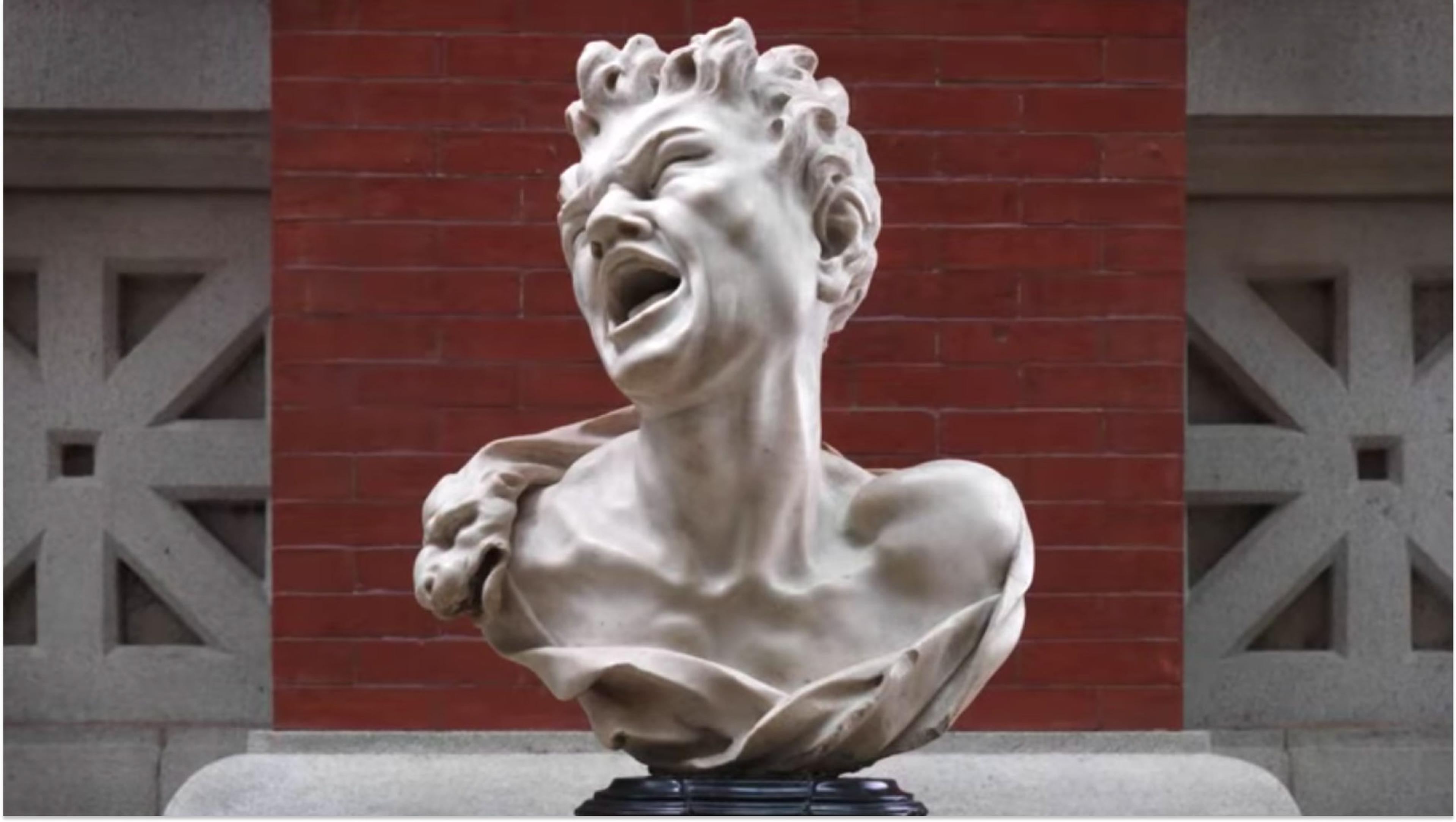 Marble bust of a screaming satyr. Behind is a red brick wall and stone slabs.