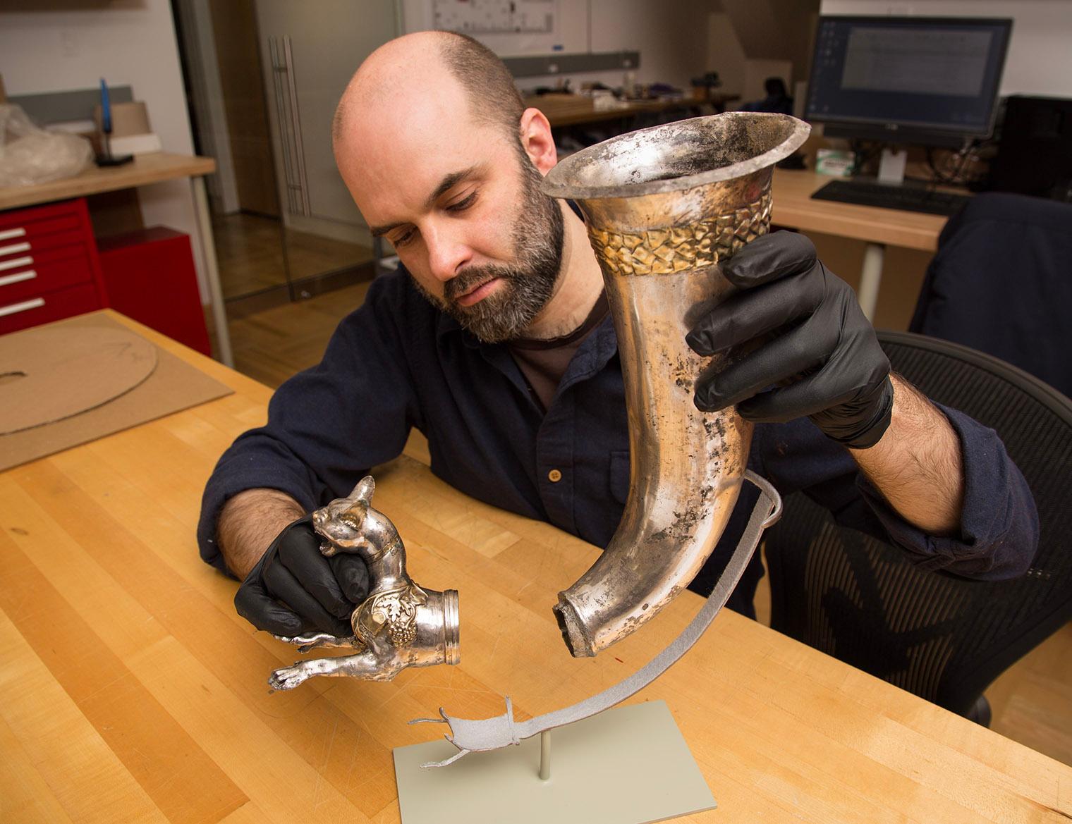 Conservation preparator Warren Bennett mounting a Parthian gilded silver rhyton for display.