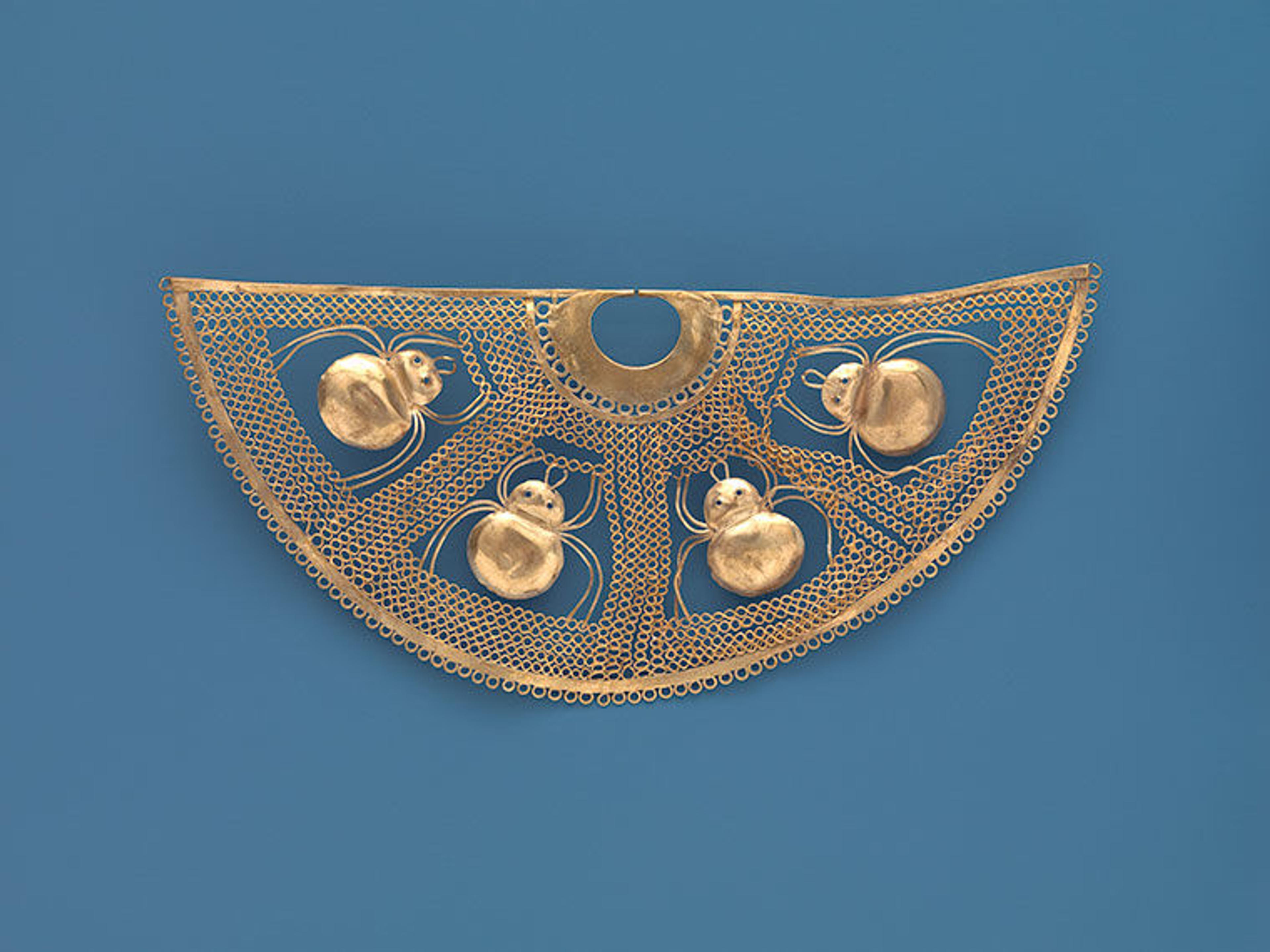 The gold nose ornament is shown on a blue background, accentuating all the details. 