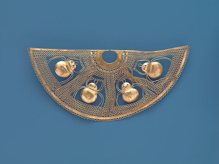 The gold nose ornament is shown on a blue background, accentuating all the details.