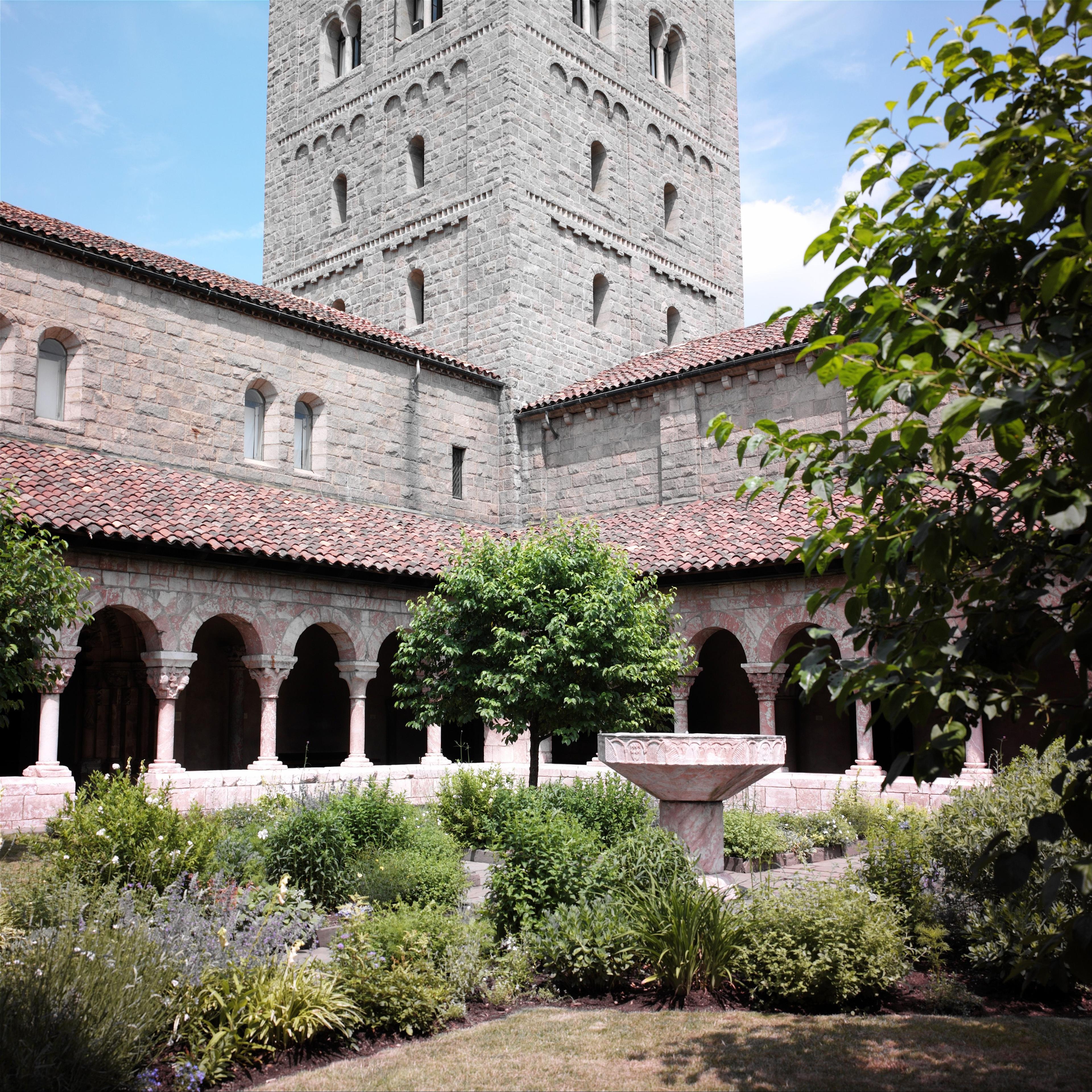 Interior courtyard with stone arches, columns, and a garden.