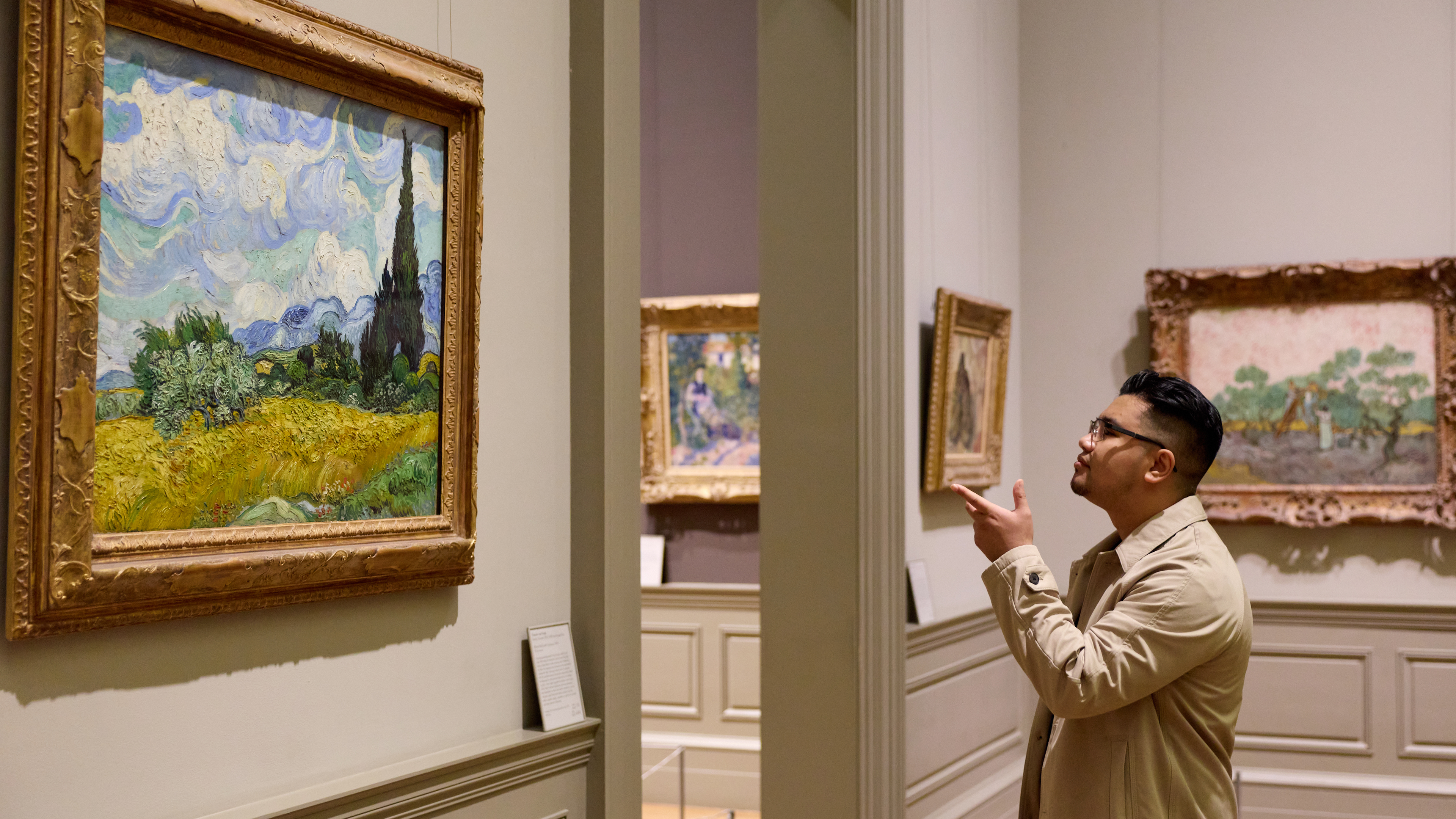 A visitor in front of two Georges Seurat paintings.