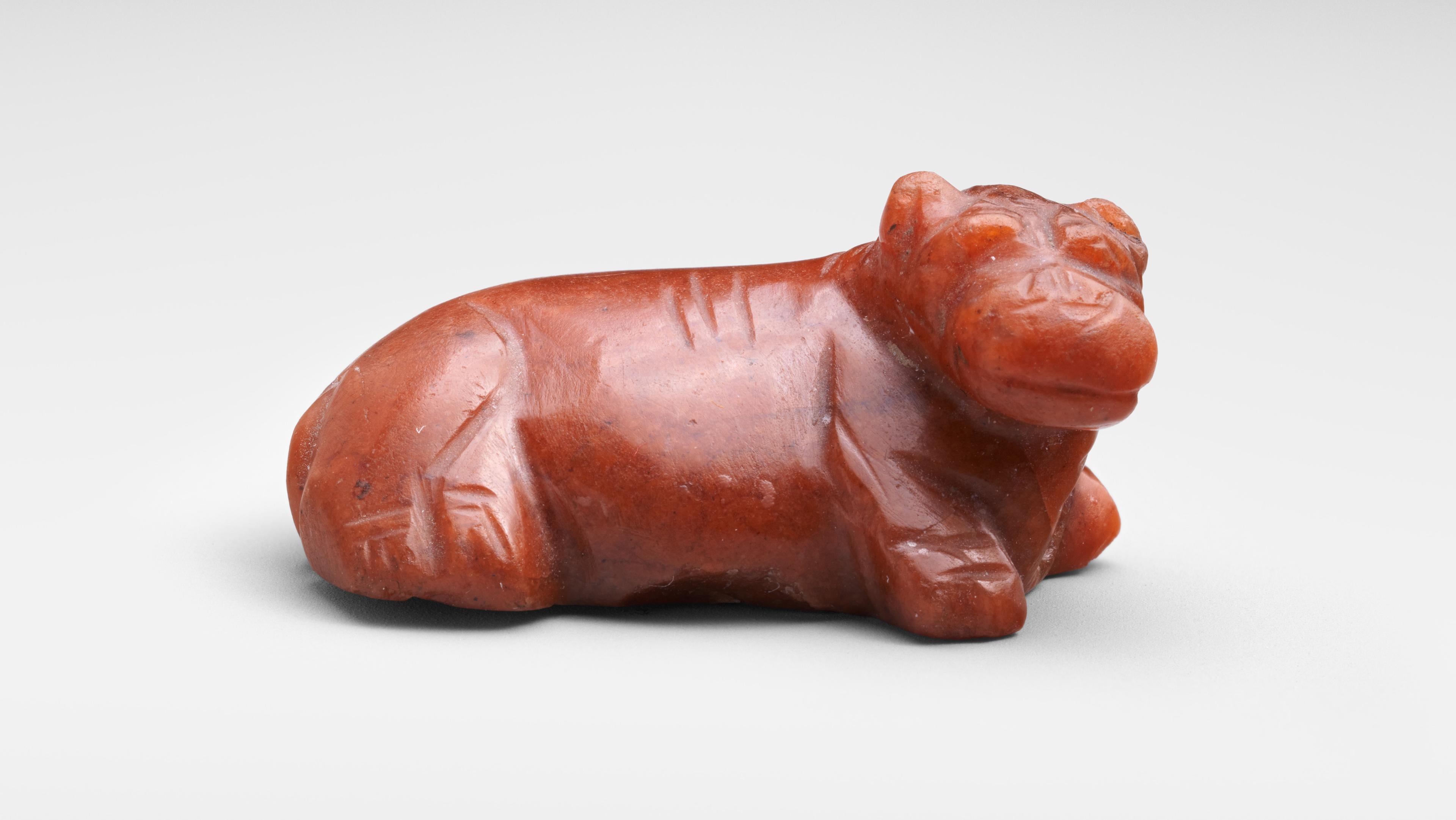 A tiny reclining hippo carved in high detail from red jasper stone.