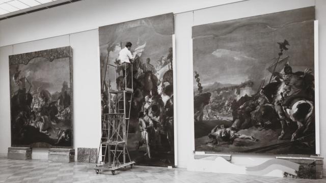A conservator standing on a ladder working on Tiepolo’s The Triumph of Marius.