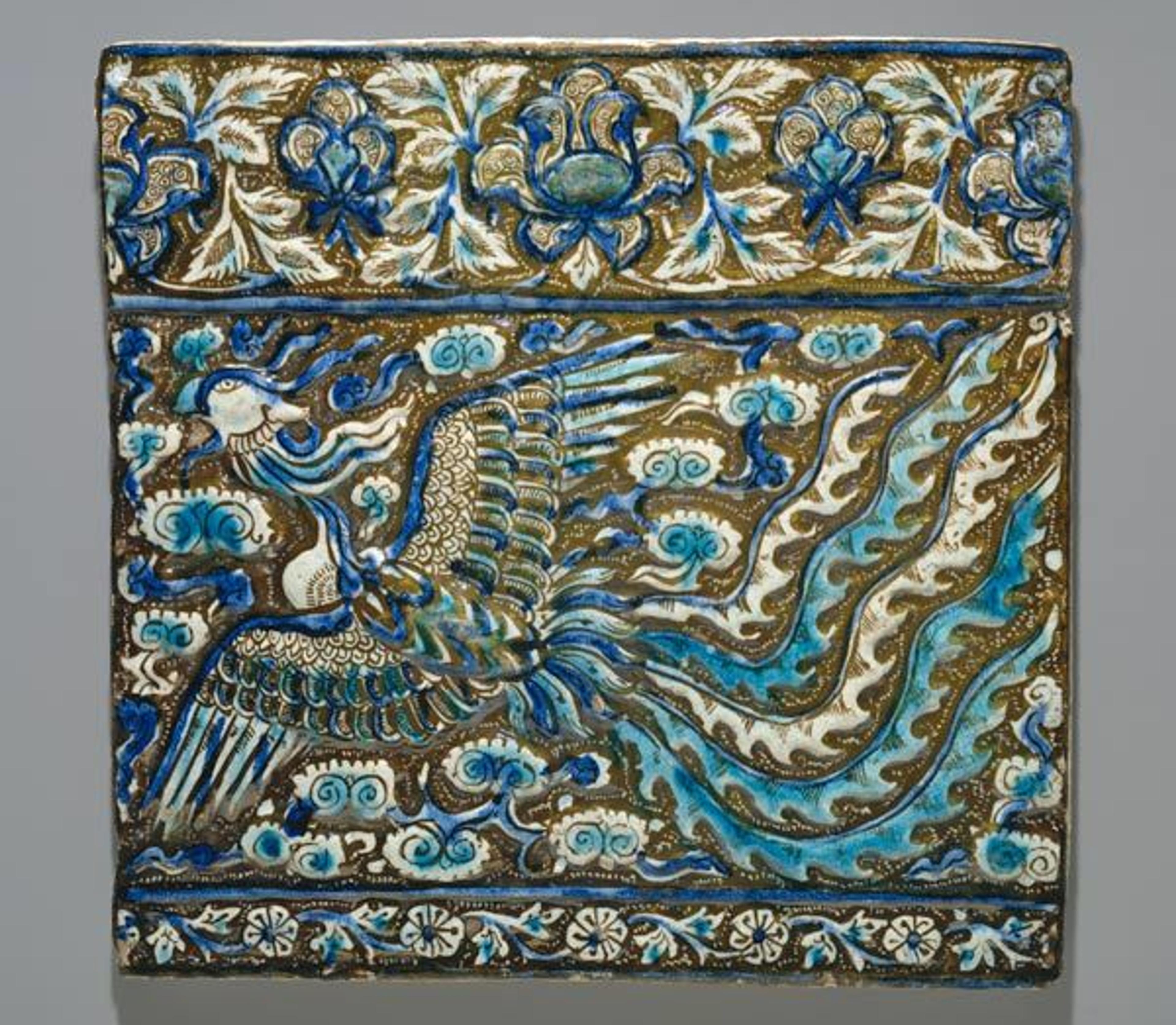 Tile with image of phoenix, late 13th century. Iran, probably Takht-i-Sulaiman. Islamic. Stonepaste; modeled, underglaze painted in blue and turquoise, luster-painted on opaque white ground. The Metropolitan Museum of Art, New York, Rogers Fund, 1912 (12.49.4)