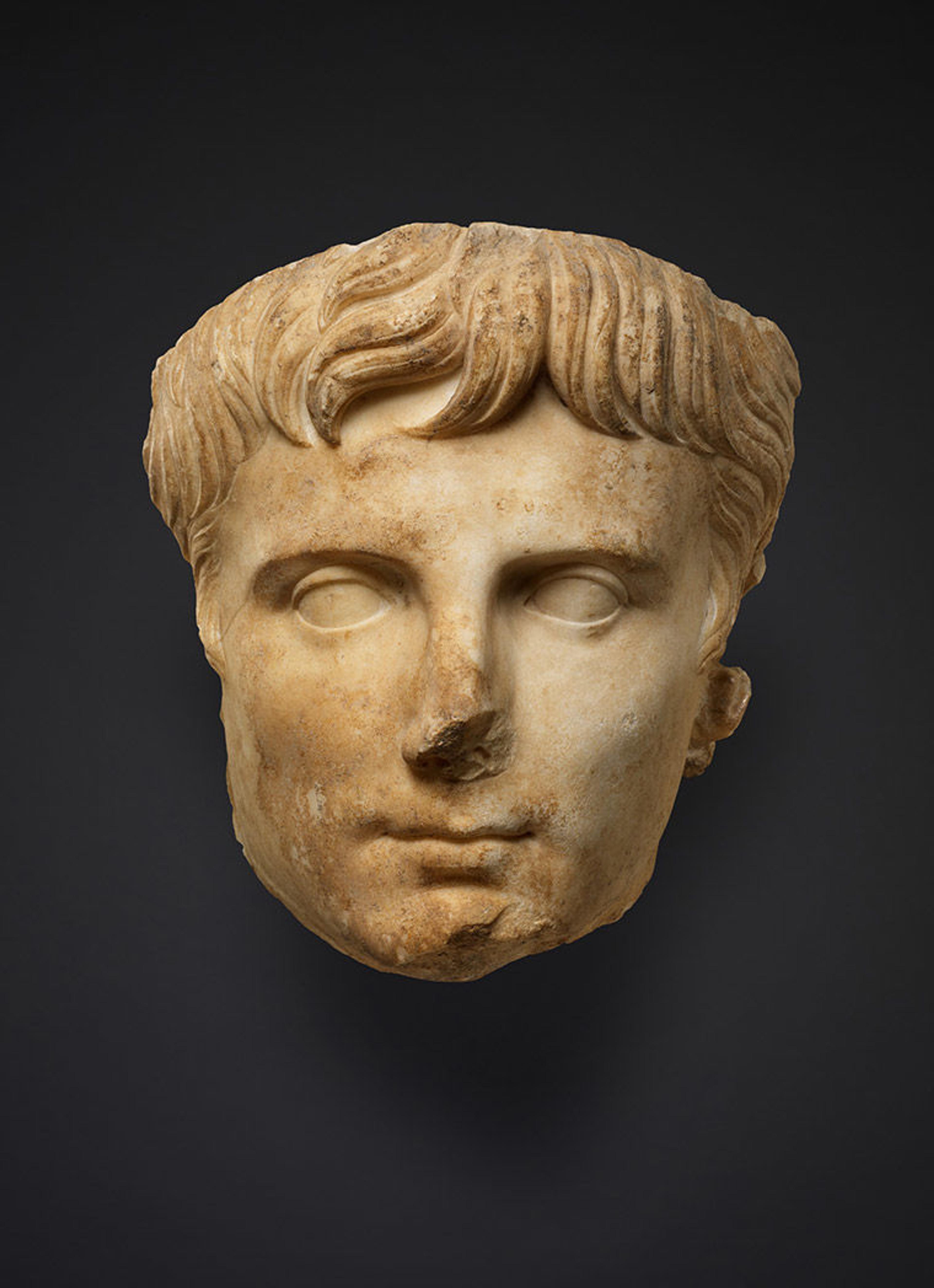 Pale sculpture of a man against a black background