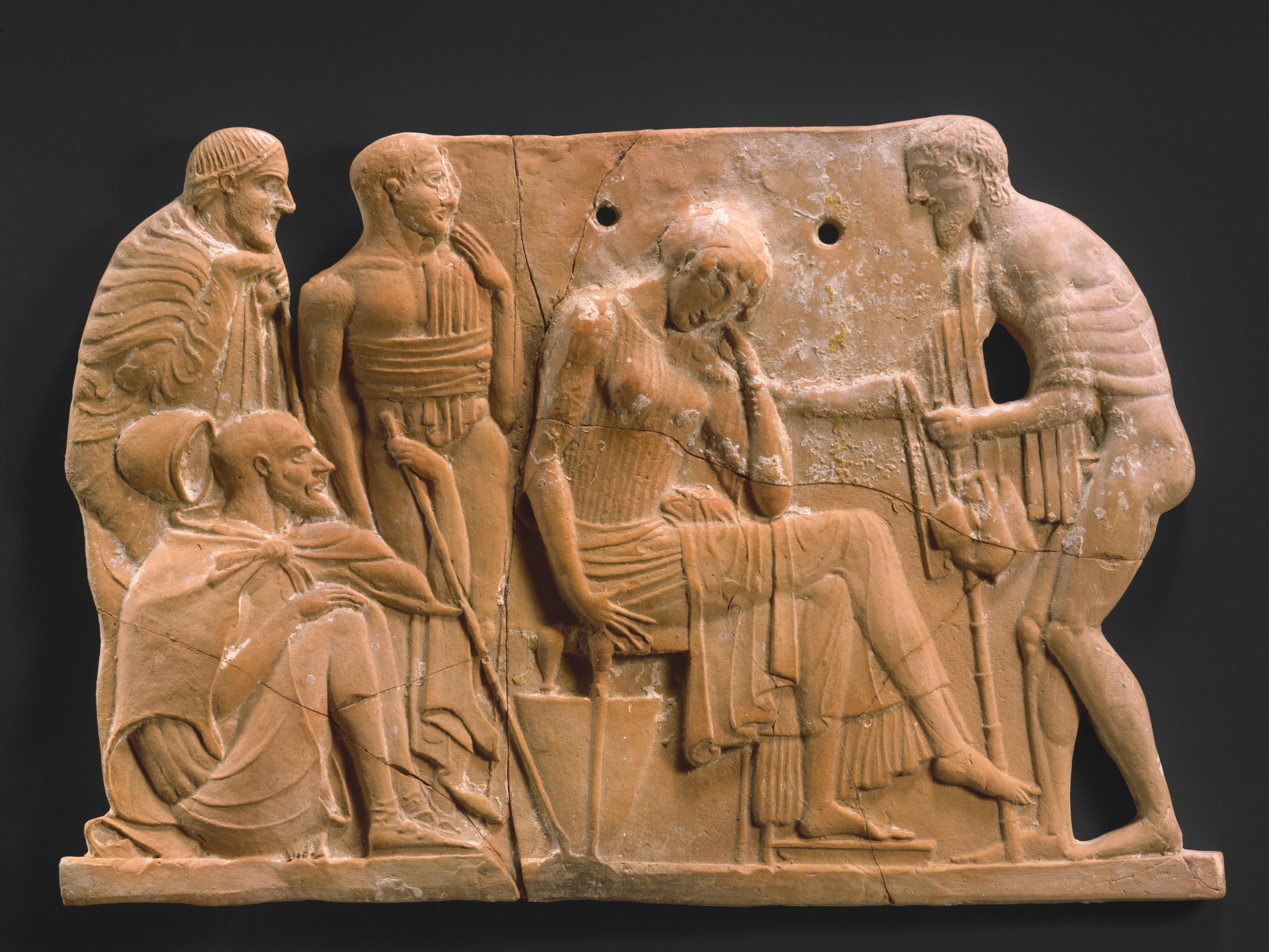 Terracotta plaque showing a man reaching tenderly towards a seated woman with her head in her hand. She is flanked by three male figures.