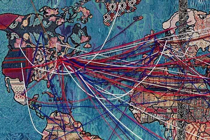 A section of artist Natalia Nakazawa's tapestry showing continents surrounding the Atlantic Ocean. Many places on these continents are connected with yarn to show movements of migration.