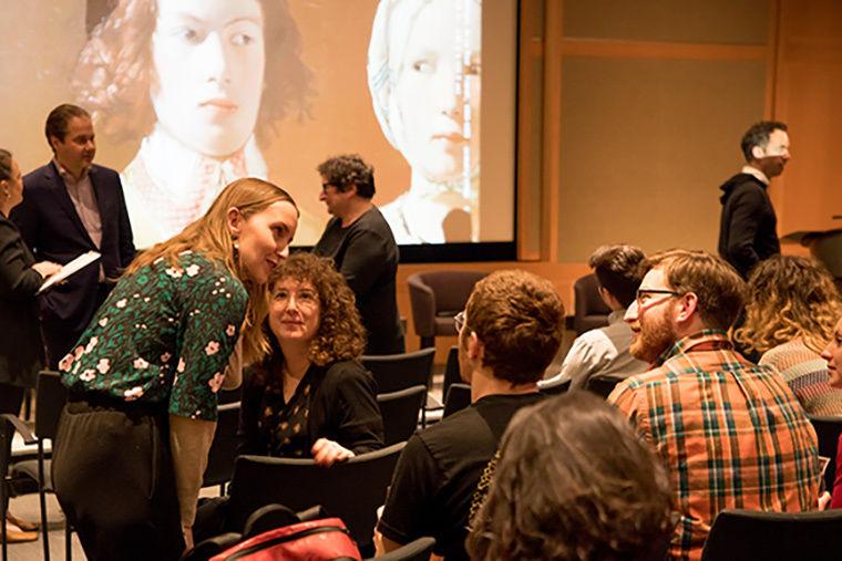 A group of panelists in a large auditorium