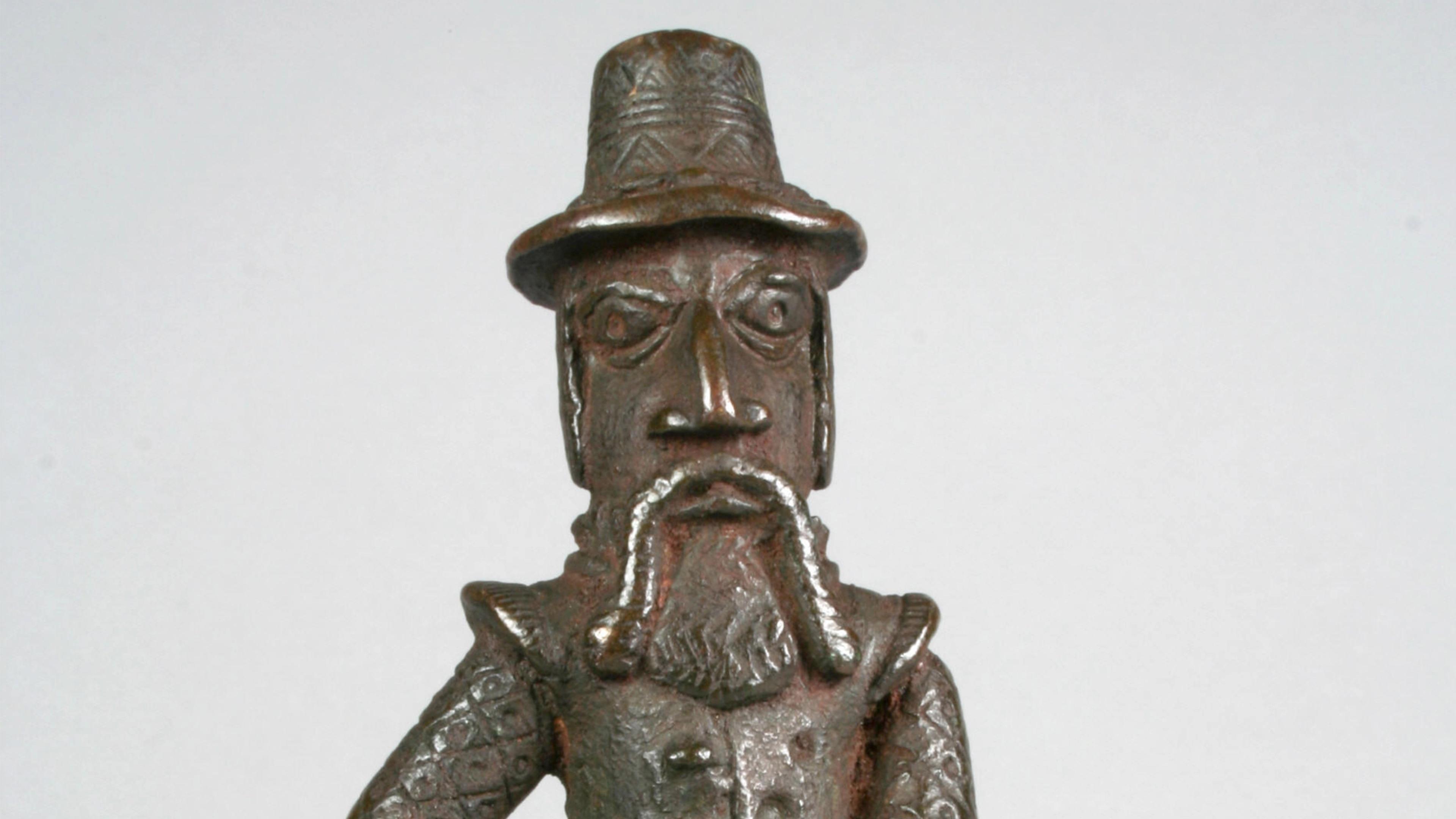 Brass sculpture of a Portuguese man with a mustache and beard, wearing a hat and doublet