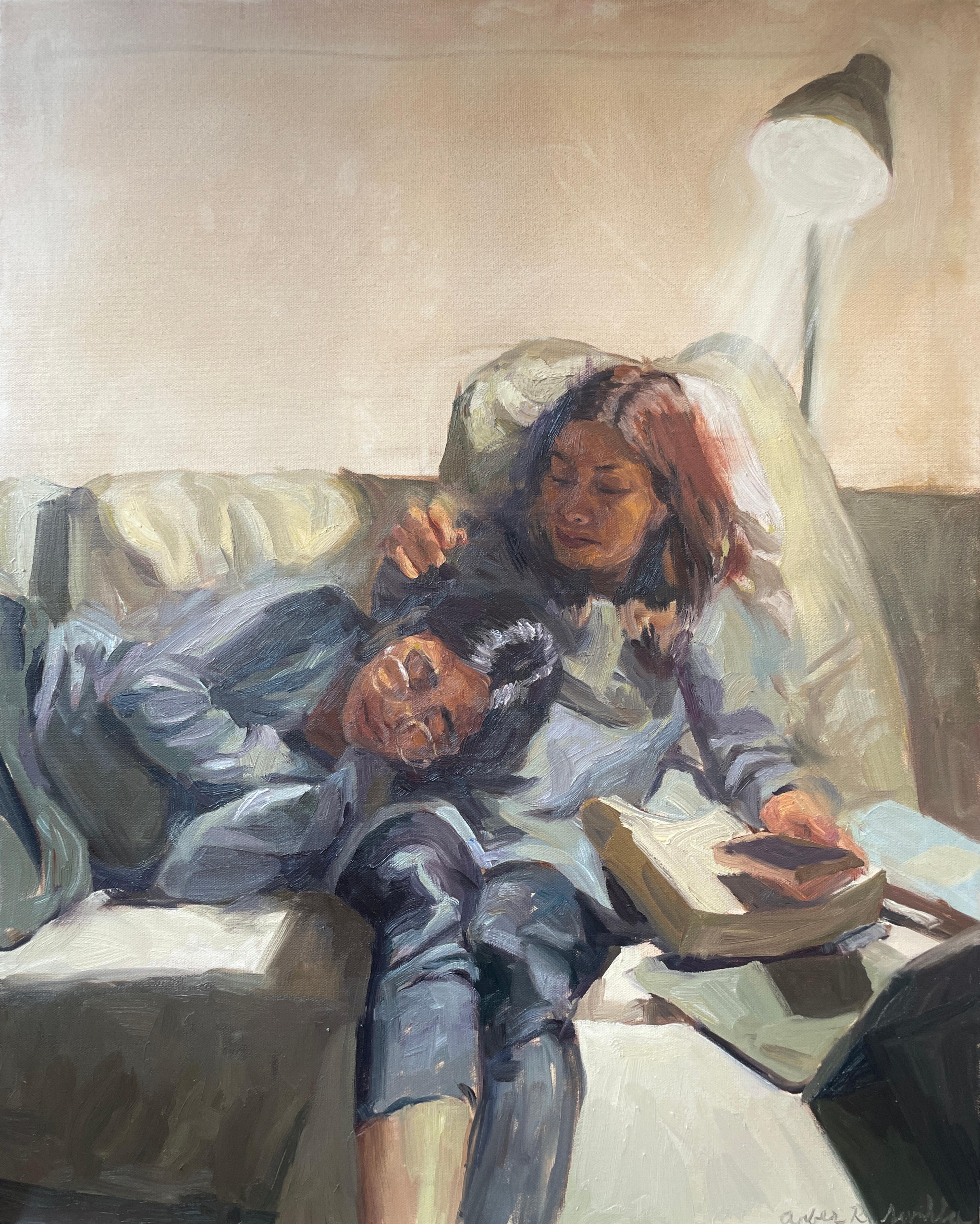 Sister laying on the couch together under lamp.