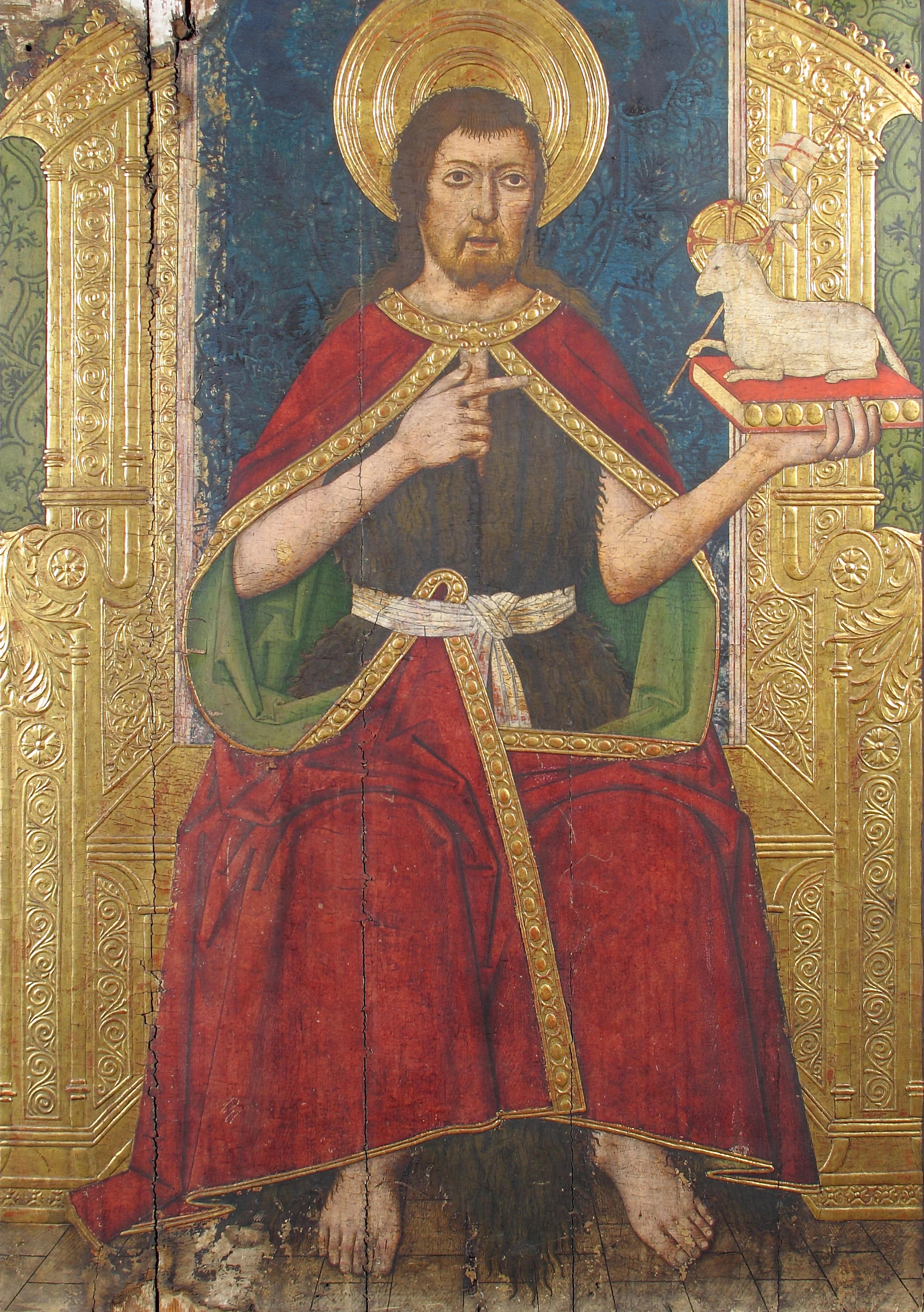 Gilded panel of a seated religious figure holding a book topped with a miniature horse.