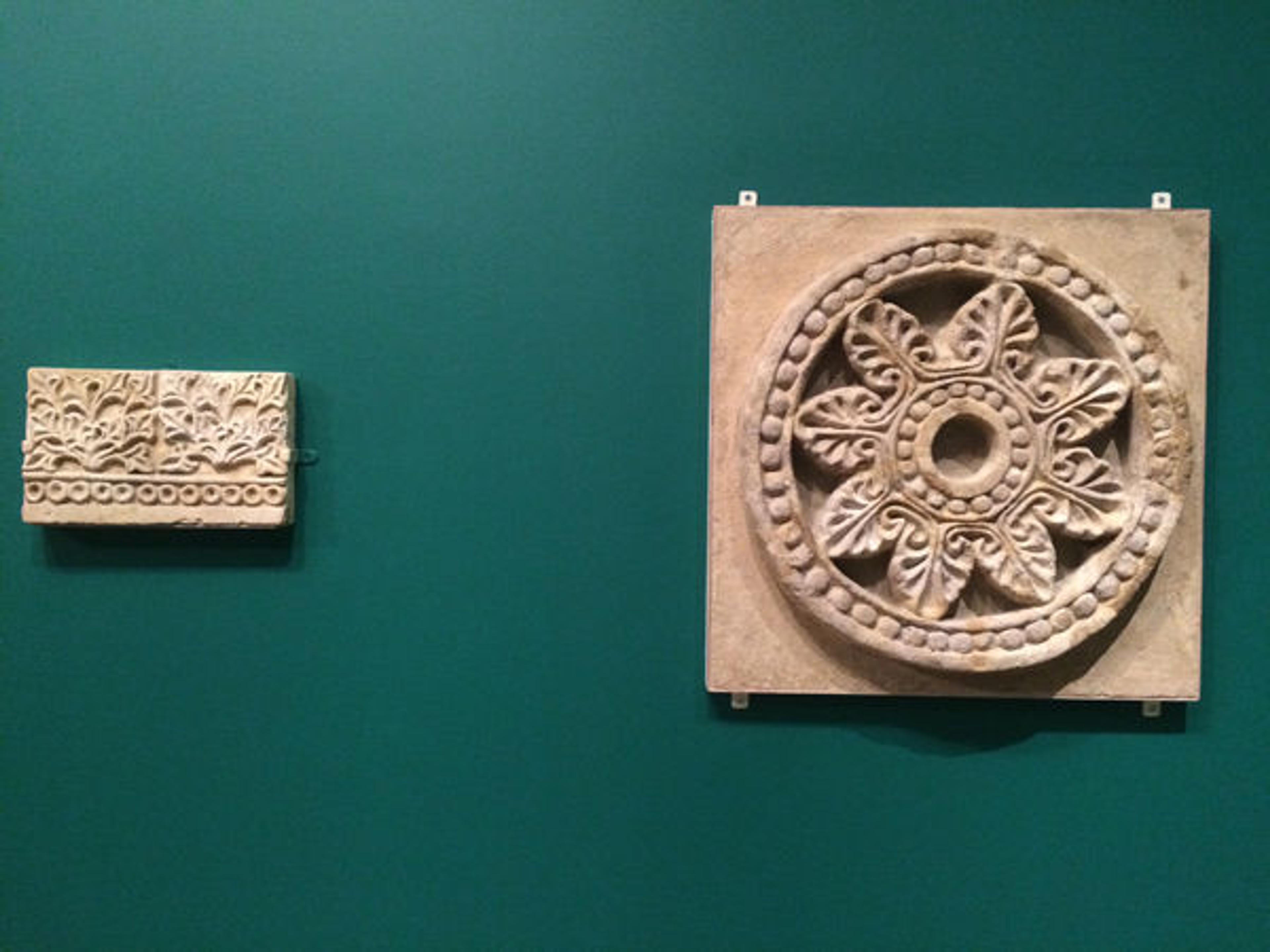 Once objects are mounted to the wall, the mounts are then painted to match the wall color of the gallery (left)
