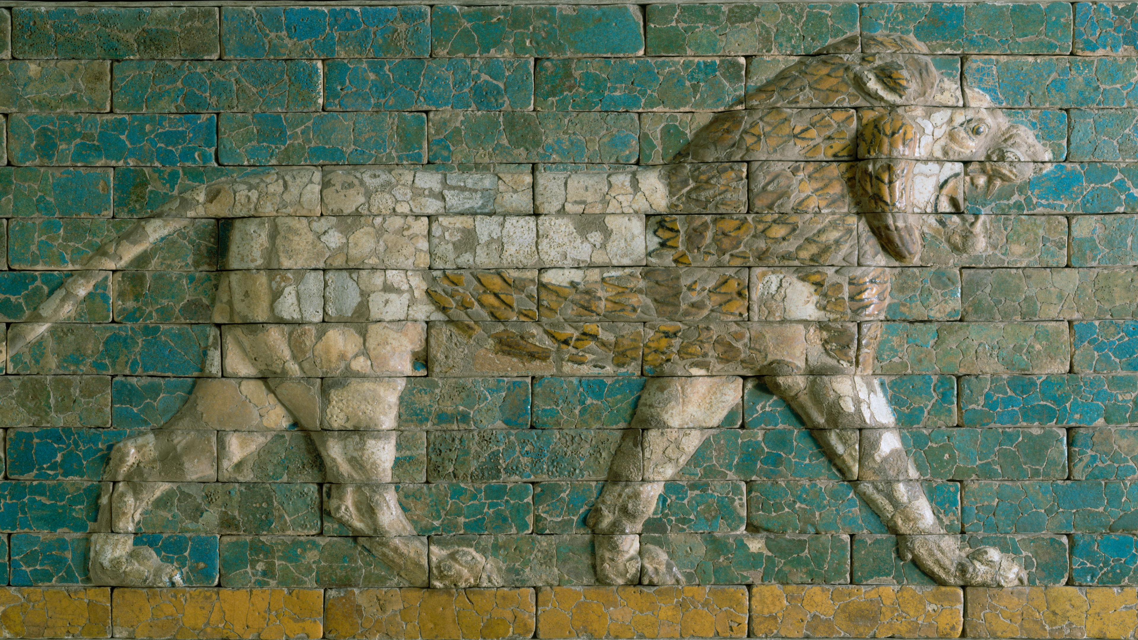 Figure of a striding lion carved and glazed on bricks.