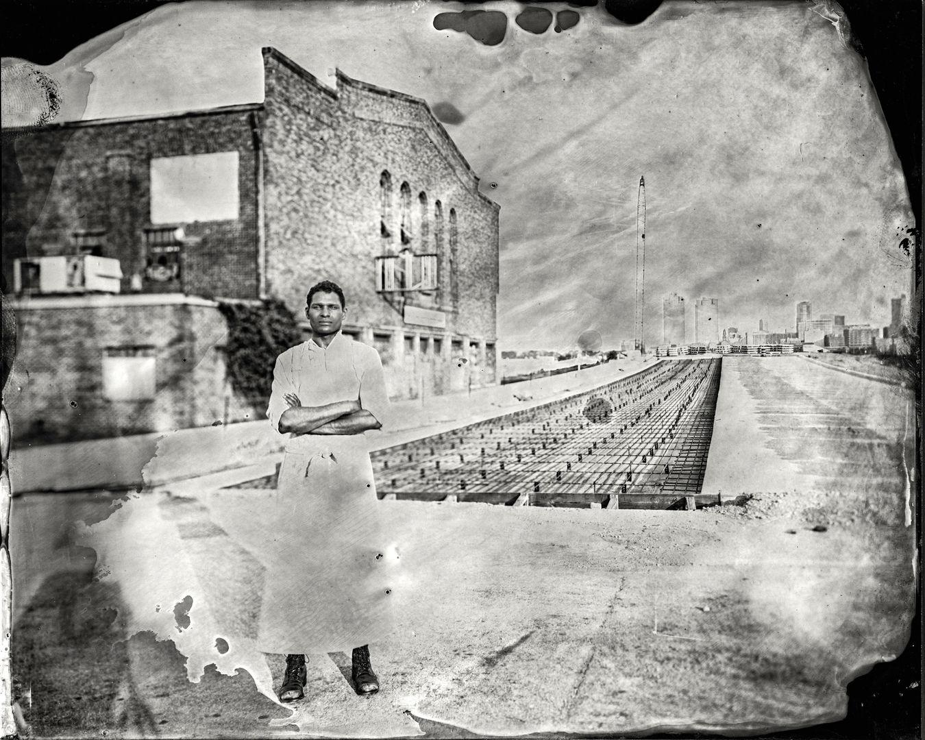 Man crosses his arms in front of an urban landscape