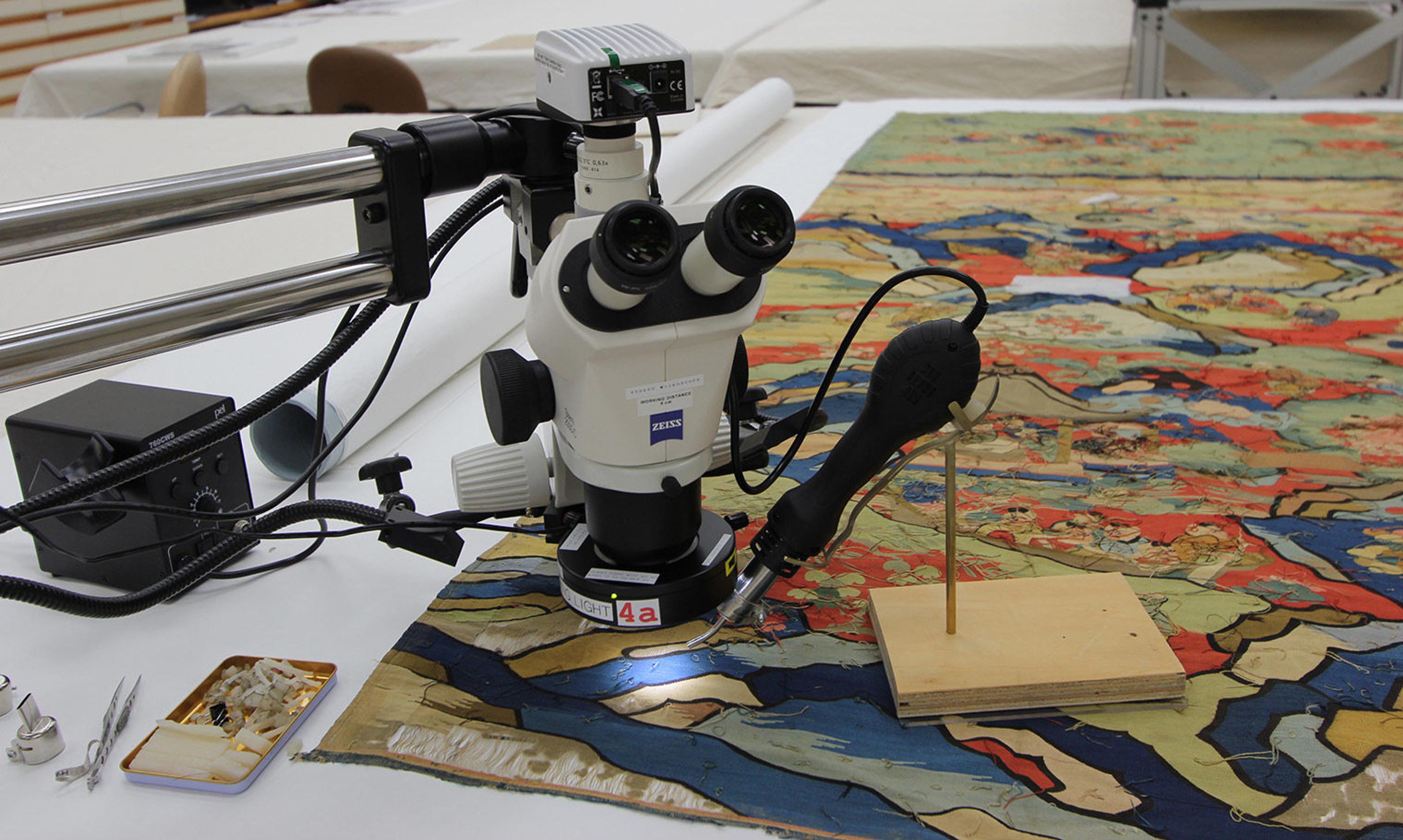 A white and black machine used to remove adhesive from the tapestry