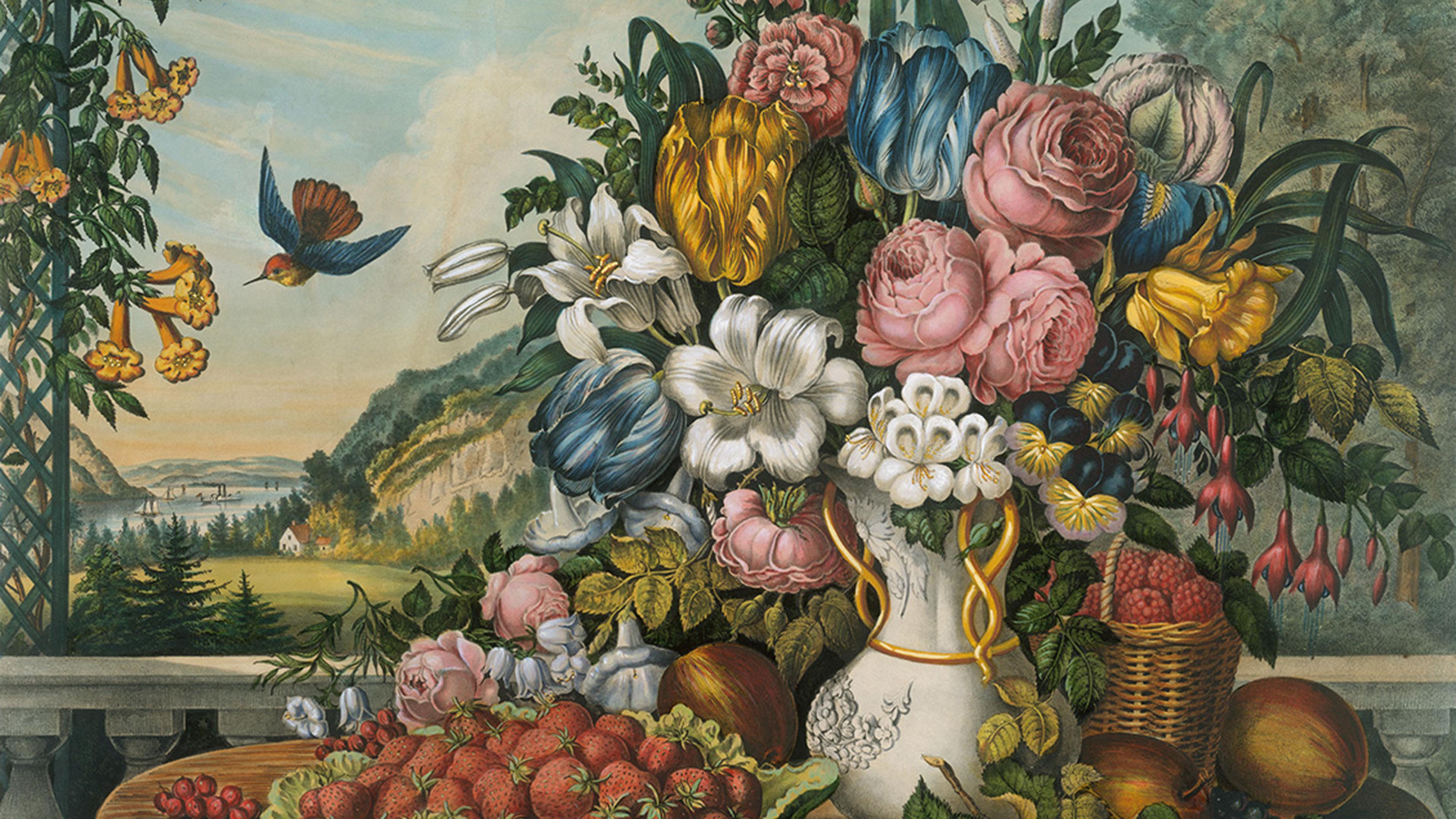 A vibrant bouquet of assorted flowers in a vase set on a table with red fruits overlooks a scenic landscape.