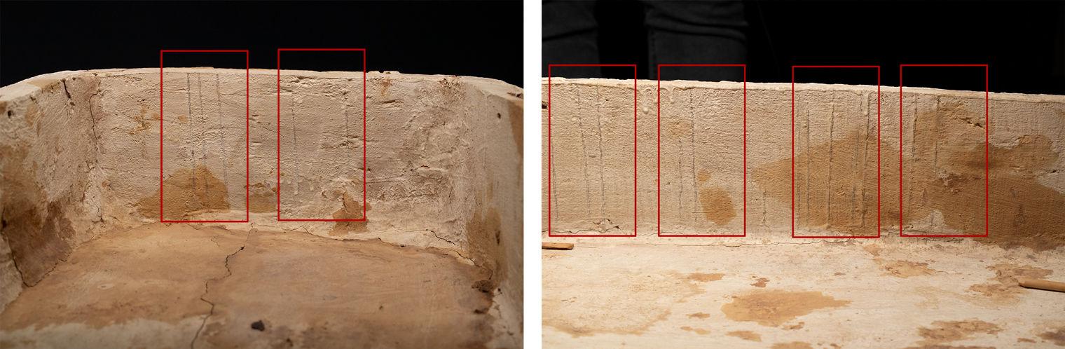 The inside of a wooden coffin that has been painted white, with drips down the sides that are marked out with red rectangles.