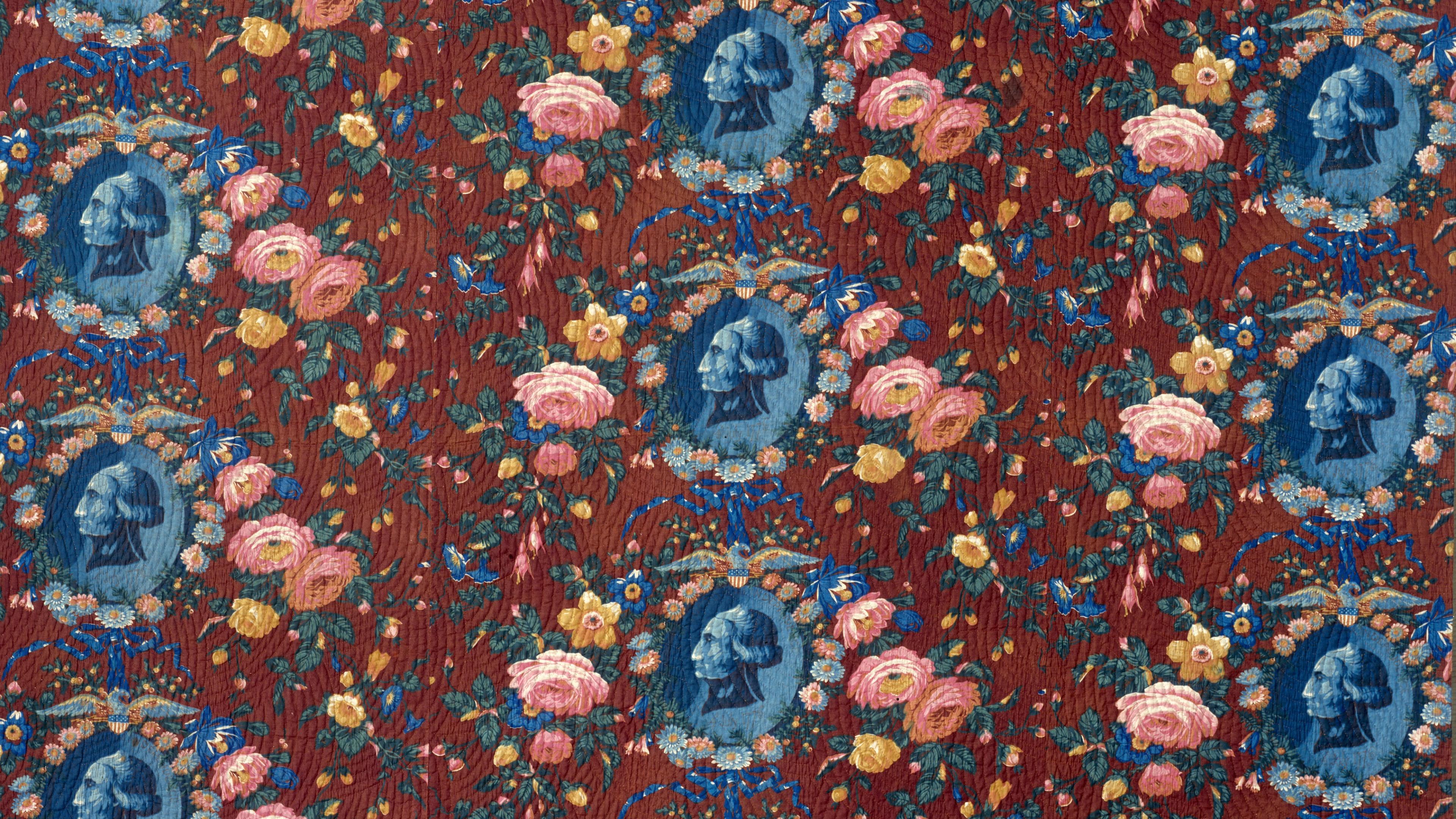 Detail of a quilt with repeating, blue-tinted portraits of George Washington surrounded by floral motifs.