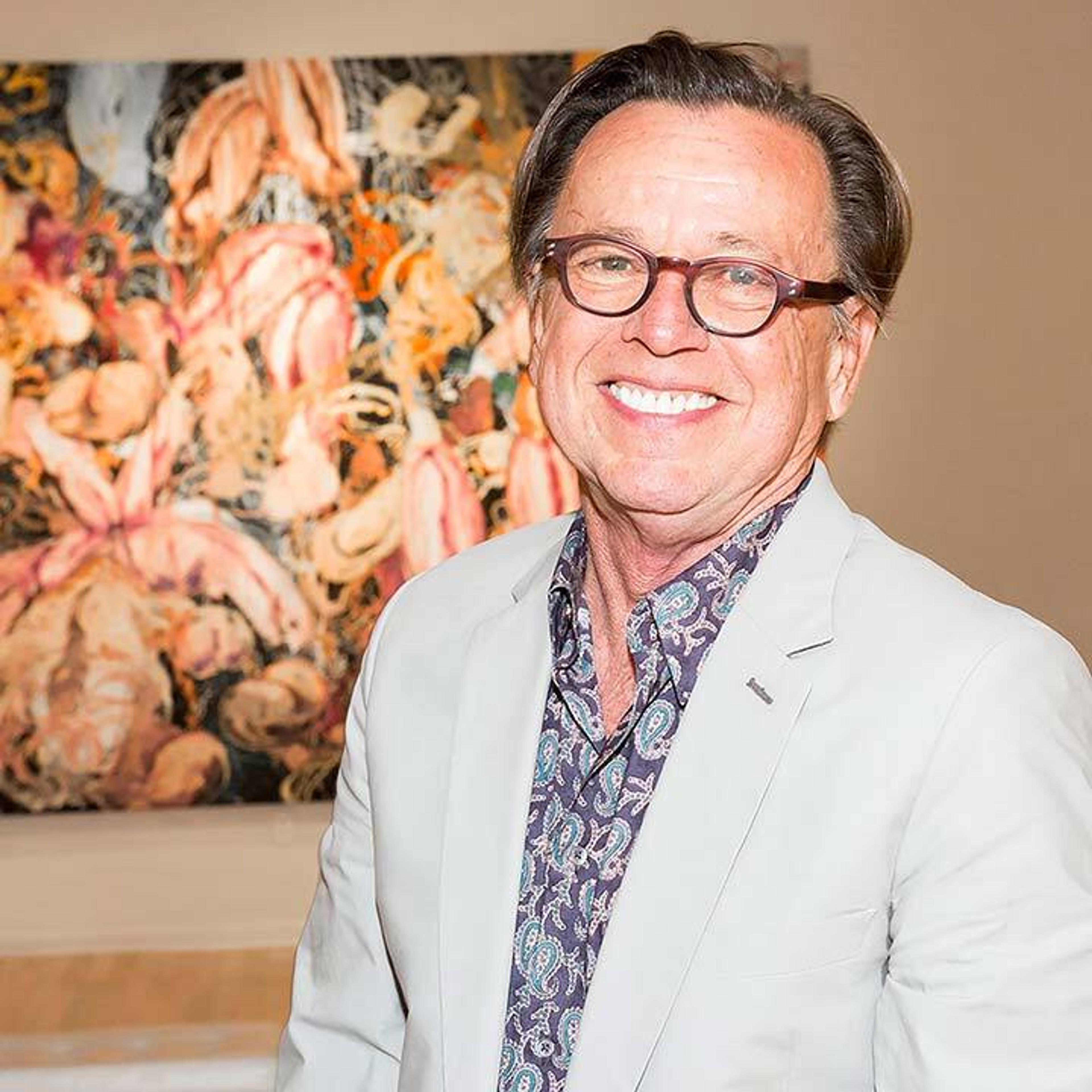 Joe Baker poses in front of a painting