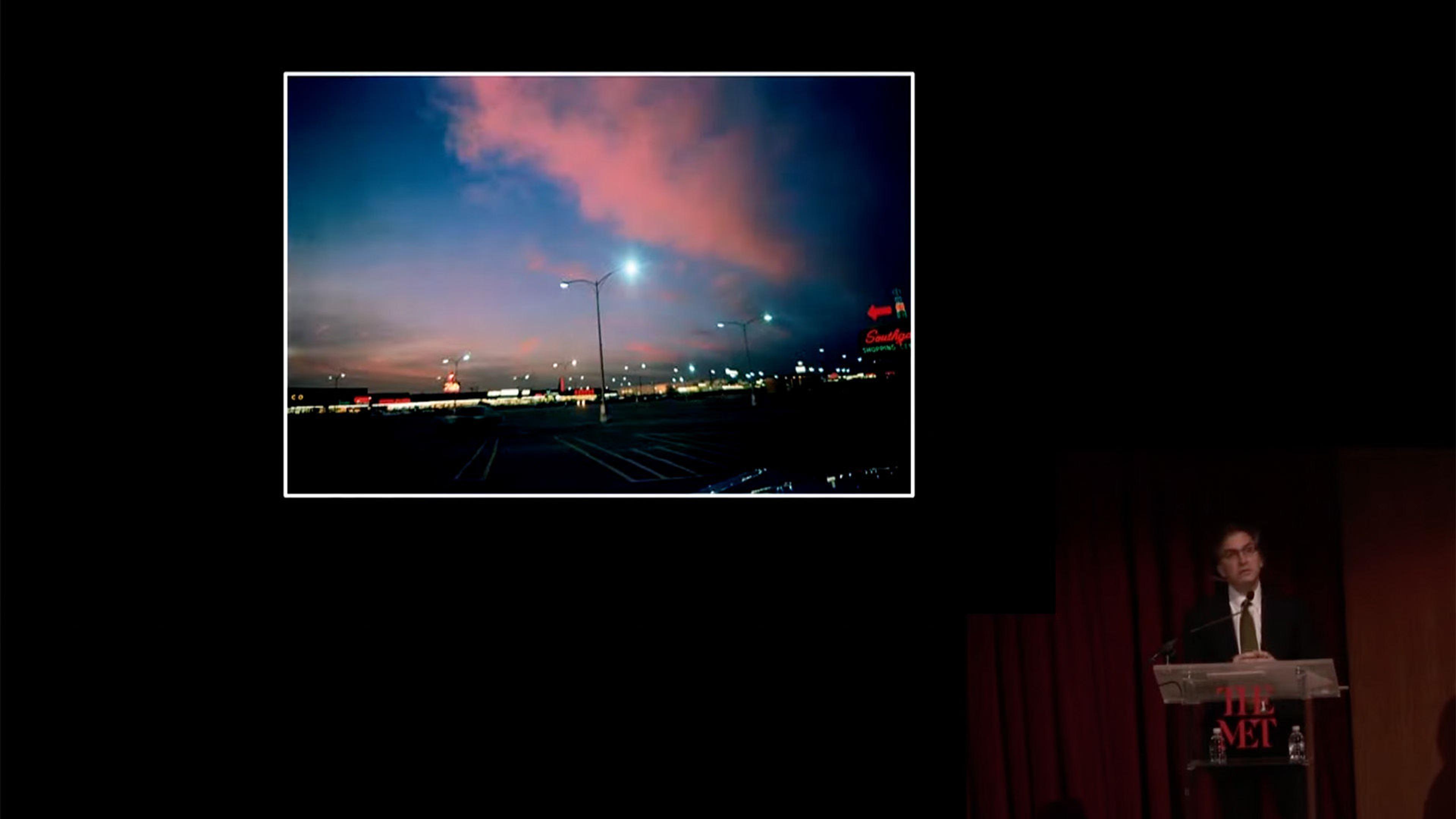 A man discussess a photograph by William Eggleston.