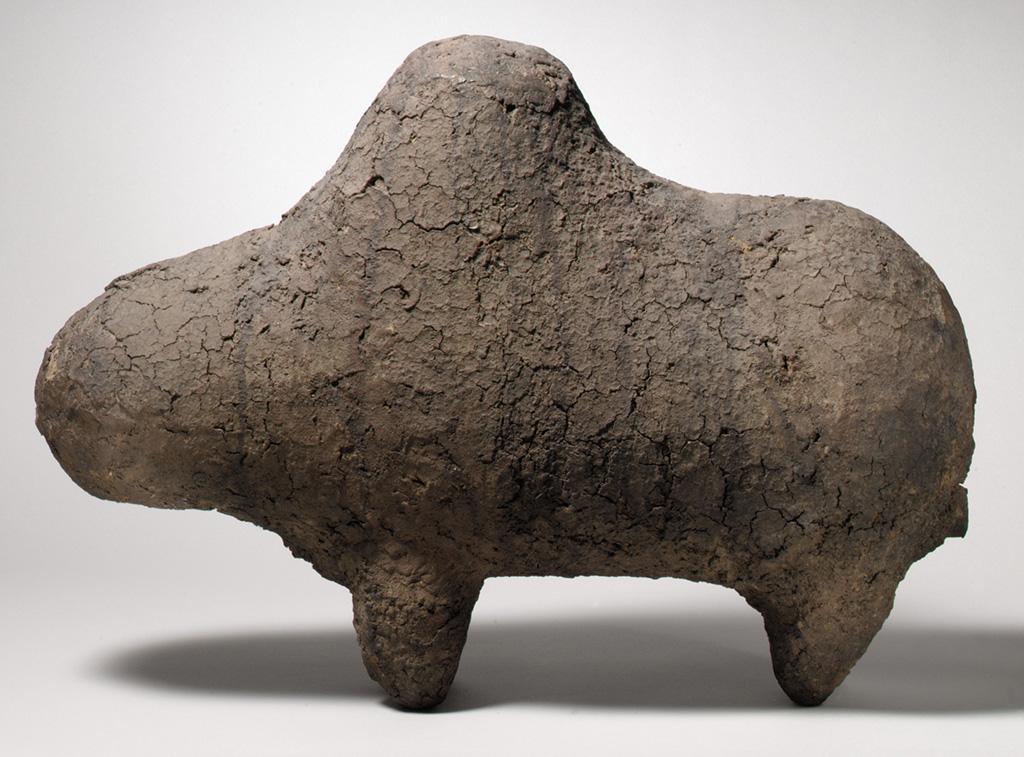 Sculpture with a rough, cracked surface of an animal with four legs and a hump.