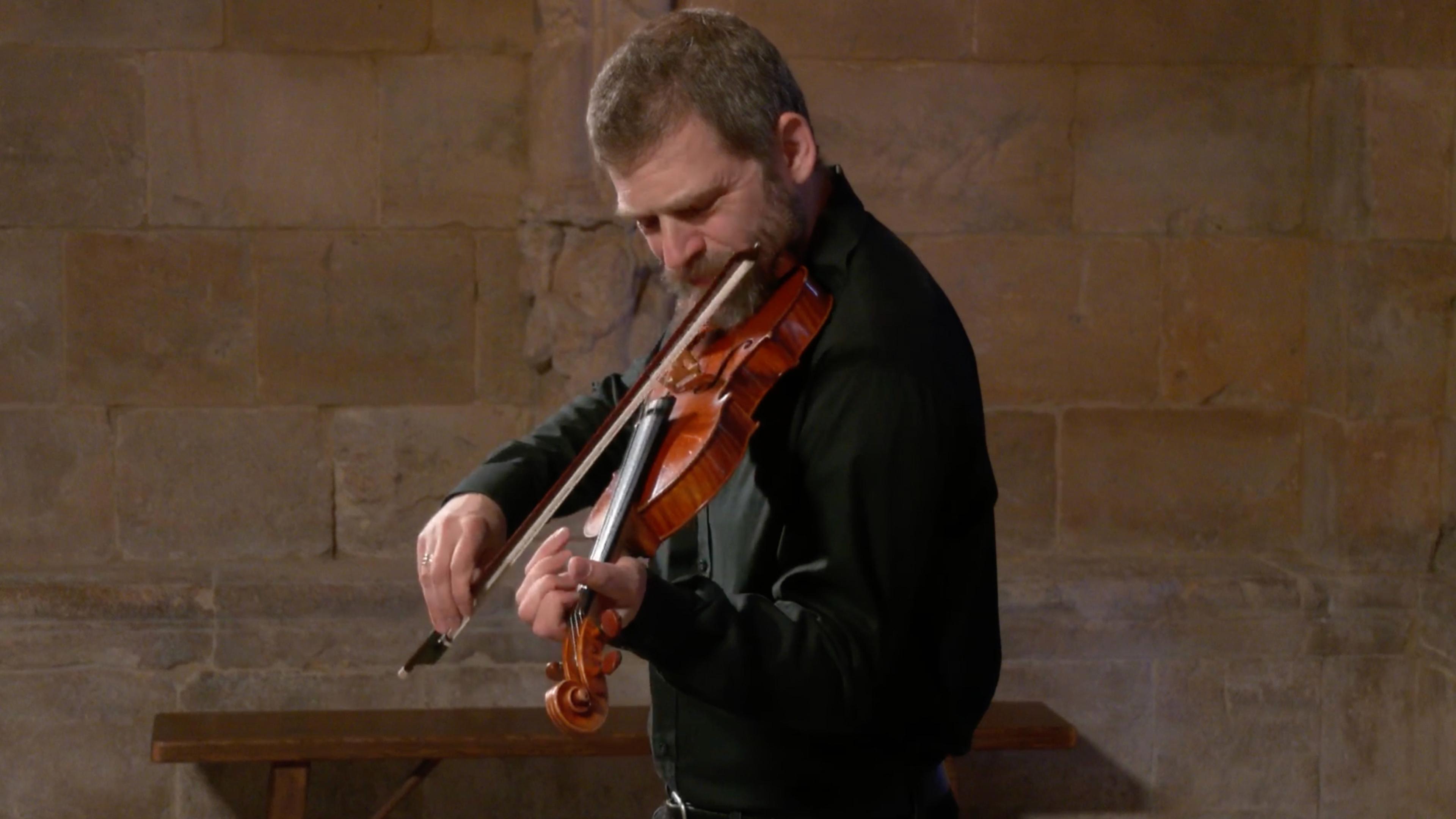 Johnny Gandelsman plays the violin against the cinderblock walls of the Fuentidueña Chapel