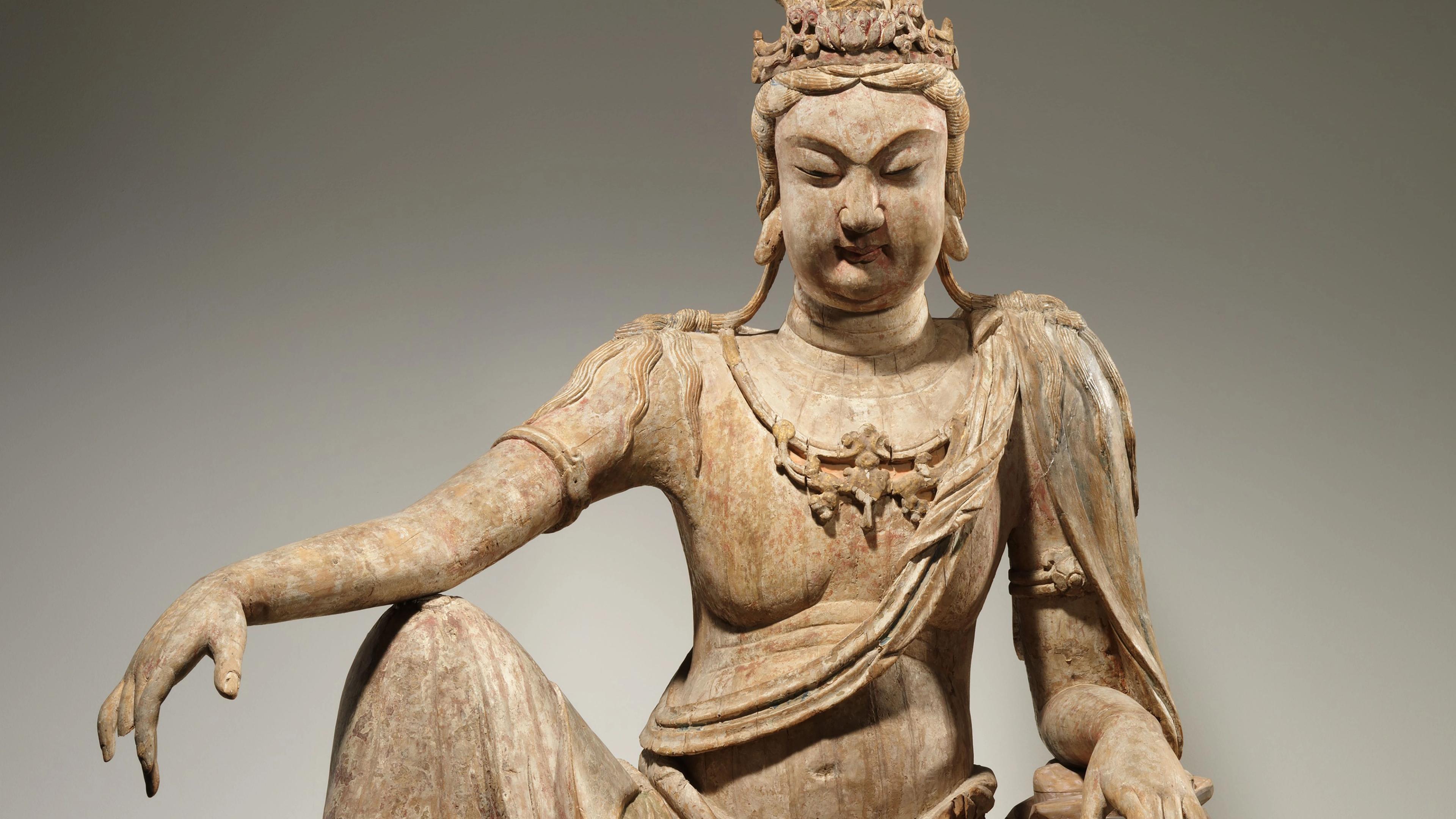 Wooden sculpture of a seated bodhisattva.