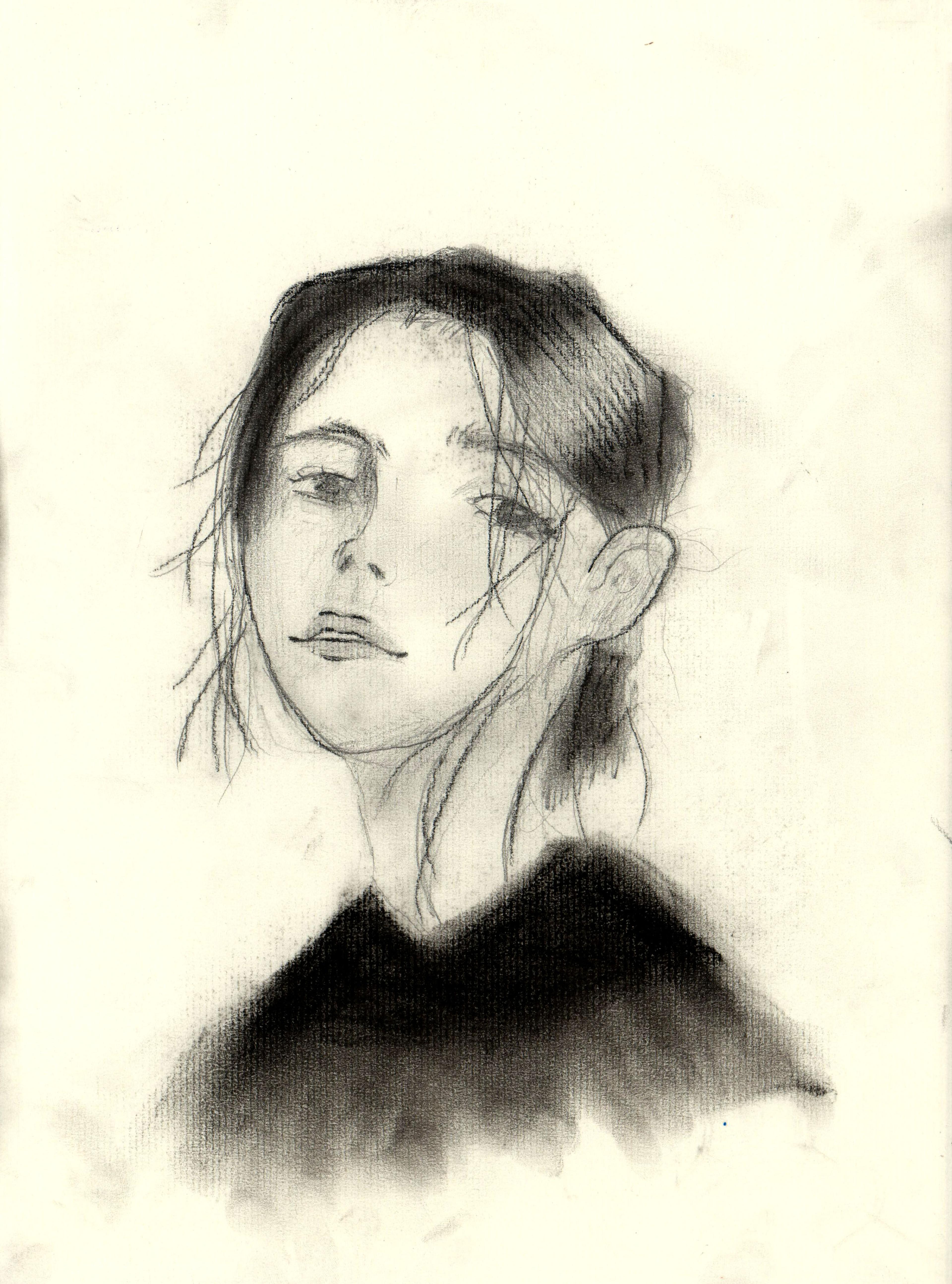 Charcoal-and–graphite pencil portrait of a young girl facing slightly to the left and looking at the viewer. She has dark neck-length hair that hangs loosely in strands on either side of her face. She wears a dark shirt that fades out in a vignette. Her chin and eyebrows are raised.